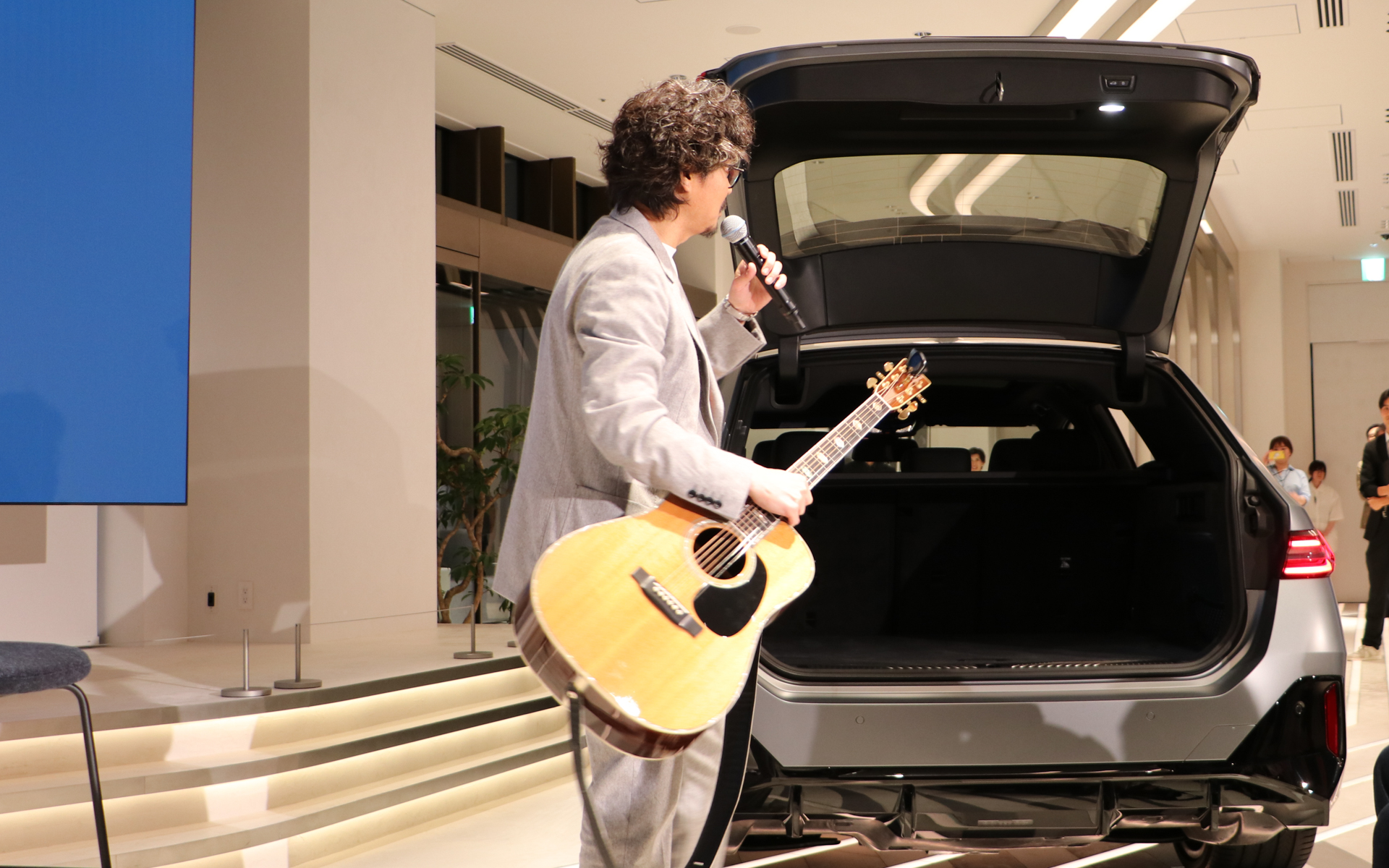 会場に展示してた新型「i5ツーリング」のラゲッジスペースからギターを取り出す小澤氏