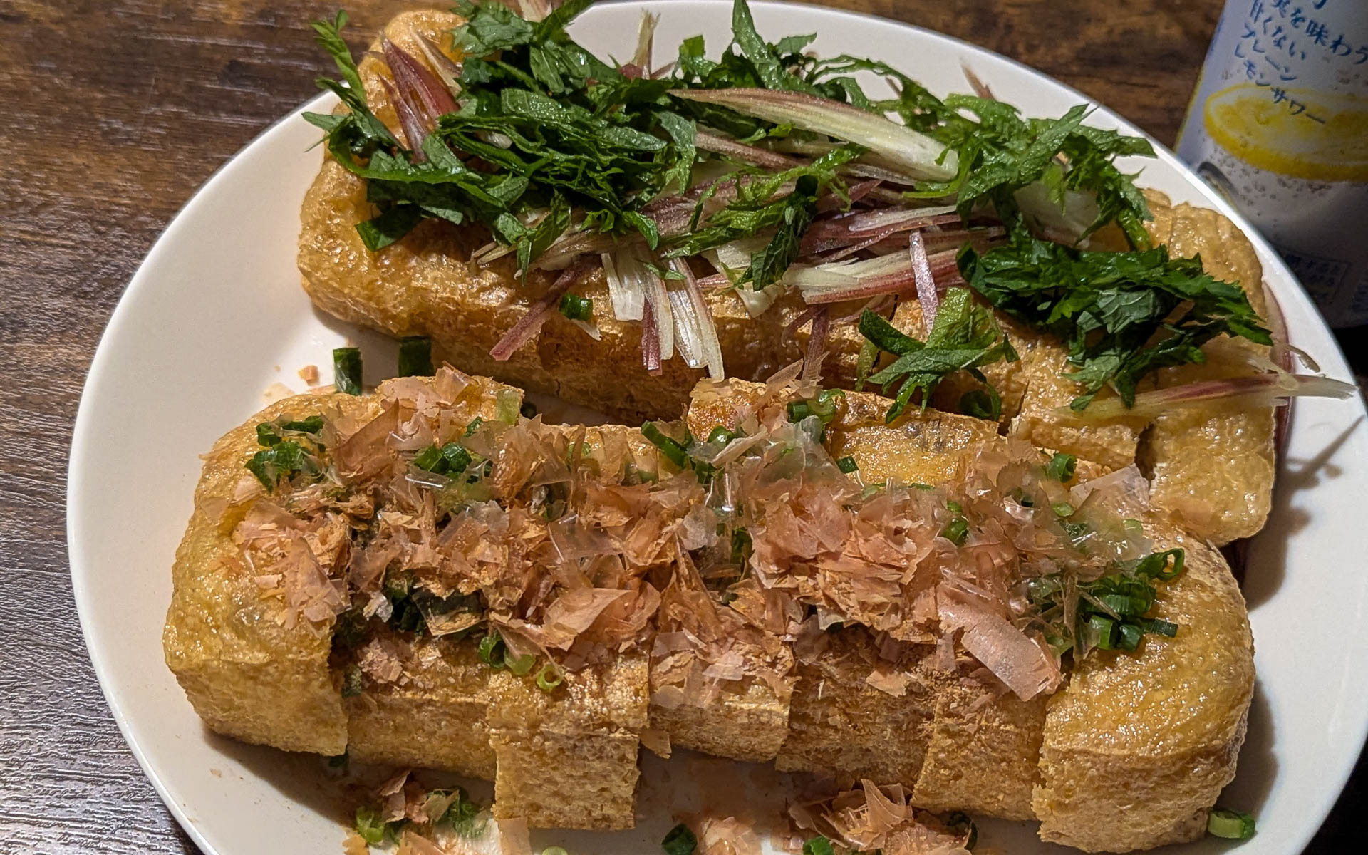 見ているだけでよだれが出てくる栃尾揚げ。食べ始める前は「こんな大きいの食べきれないよー」と思うのですが、いつも気付くとなくなっています。ちなみに、右奥に見えるのは、グルメWatchの編集長にそそのかされて購入した未来のレモンサワー。自分の中で大大大ヒット商品なのですが、数量限定かつエリア限定販売なのが残念……。8月27日に再販が決まっているそうなので気になる方は要チェックです