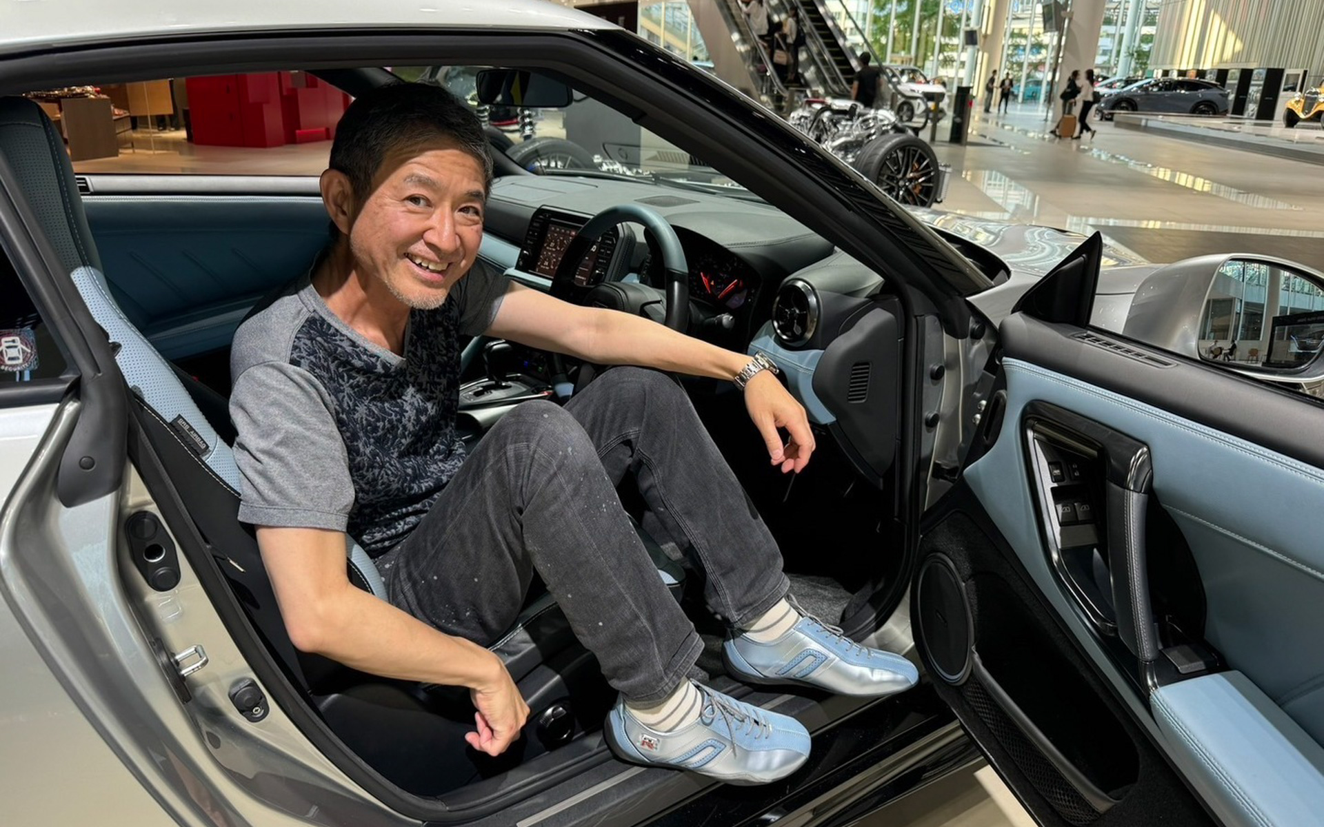 完成したシューズとGT-Rの車体色を見比べる田村宏志⽒（日産自動車 ブランドアンバサダー）