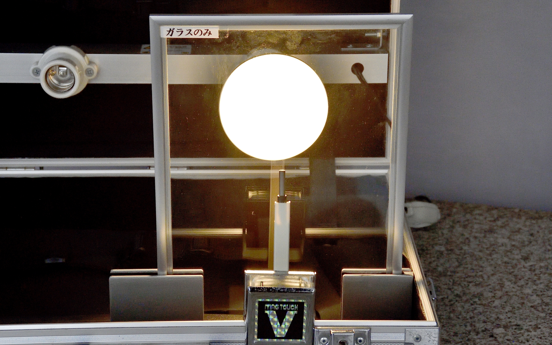 フィルムの遮熱性能を測る計測器。大きな白熱電球はかなりの熱を発しているため、透明ガラスで遮ってもわずか3分程度で温度計は50℃以上を指した