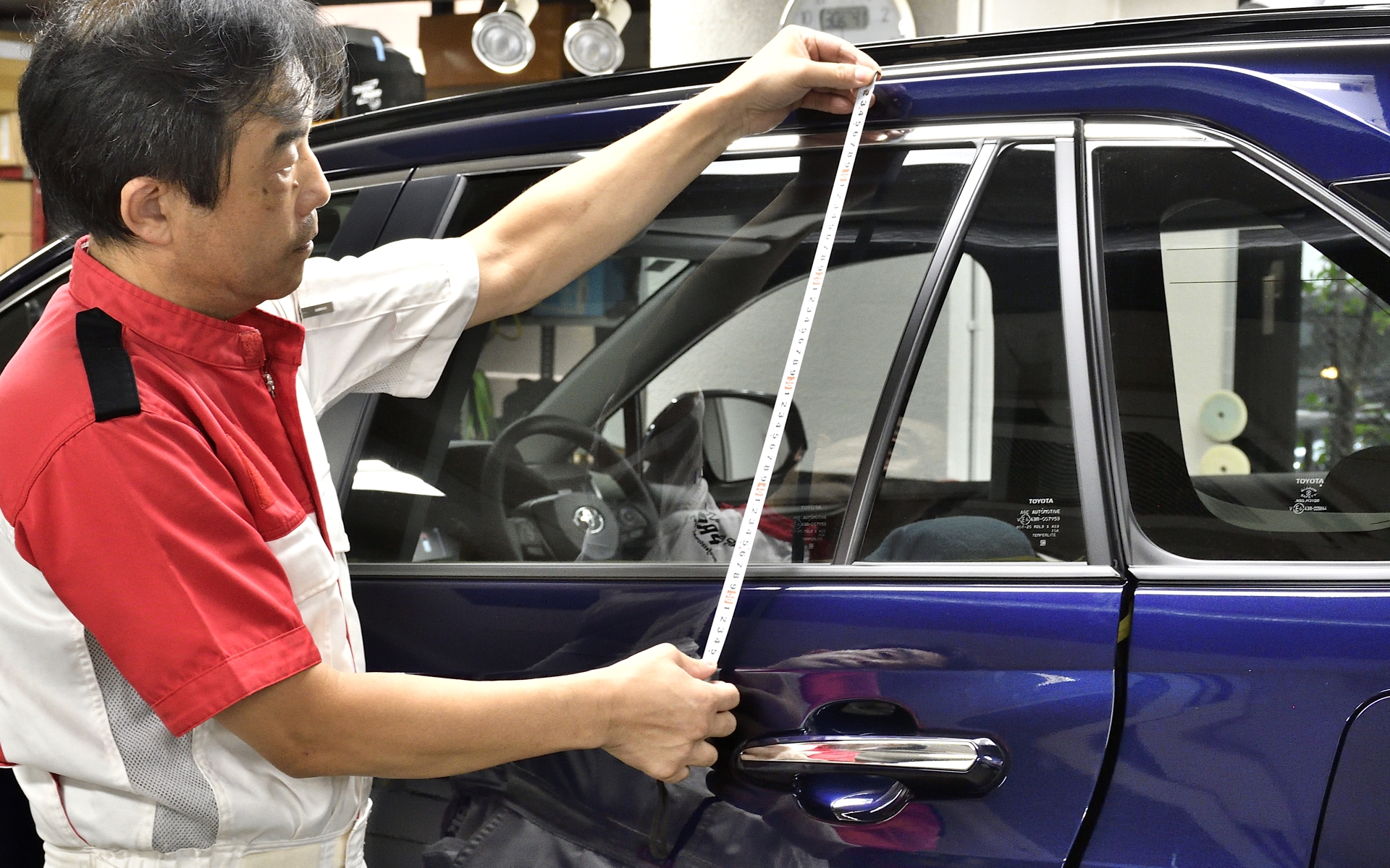 側面ガラスのフィルム貼りの第一歩は採寸から。これをベースに大まかなカットをする。担当する内田氏の施工実績は数万台におよぶそうだ