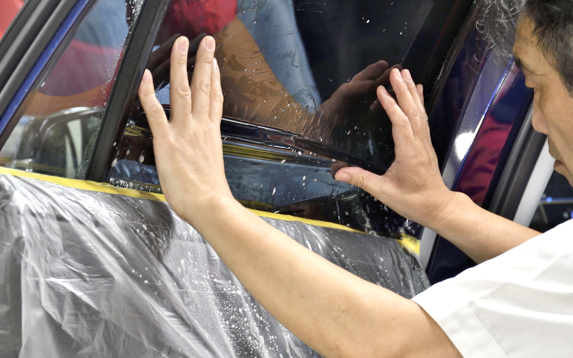 8.フィルムの下の部分は滑り込ませるように内装の内側に差し込む。ウィンドウを下げてもめくれることがないようにするのも技術が必要だ