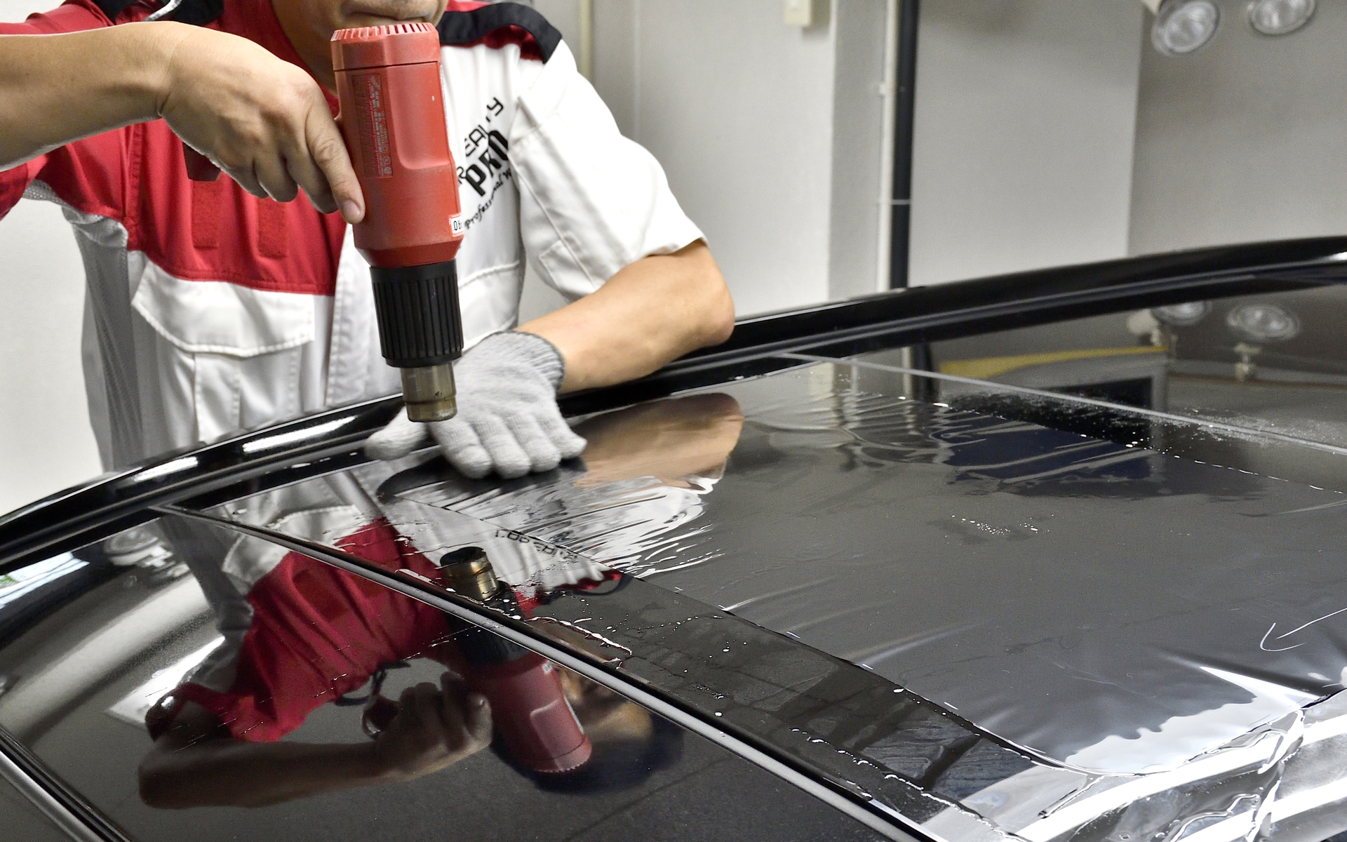 グラスルーフは立体的な形状のため、ヒートガンでフィルムとガラスの曲面を成形していく