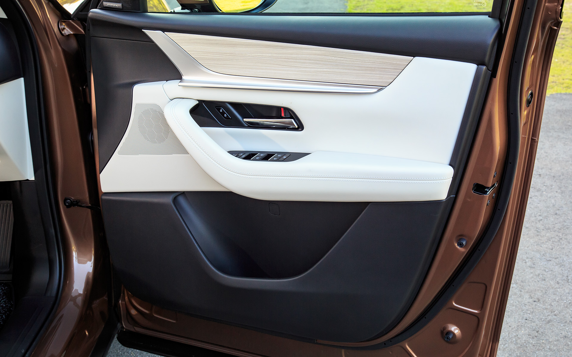 運転席ドアトリム。木目調、ステンレス、ホワイトレザー、樹脂とさまざまな素材が折り重なる