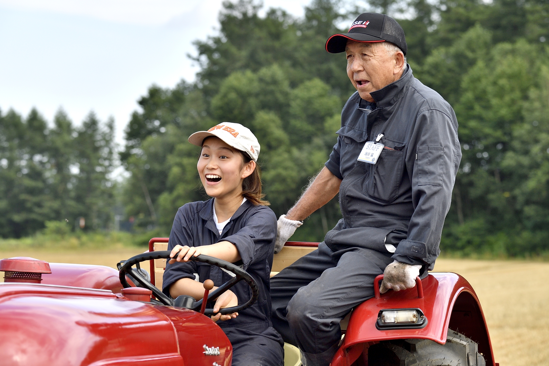 小麦畑でポルシェトラクターに乗る学生たちからは思わず笑みが。自らの手で直したトラクターに乗る気持ちが素直に表れた瞬間だ