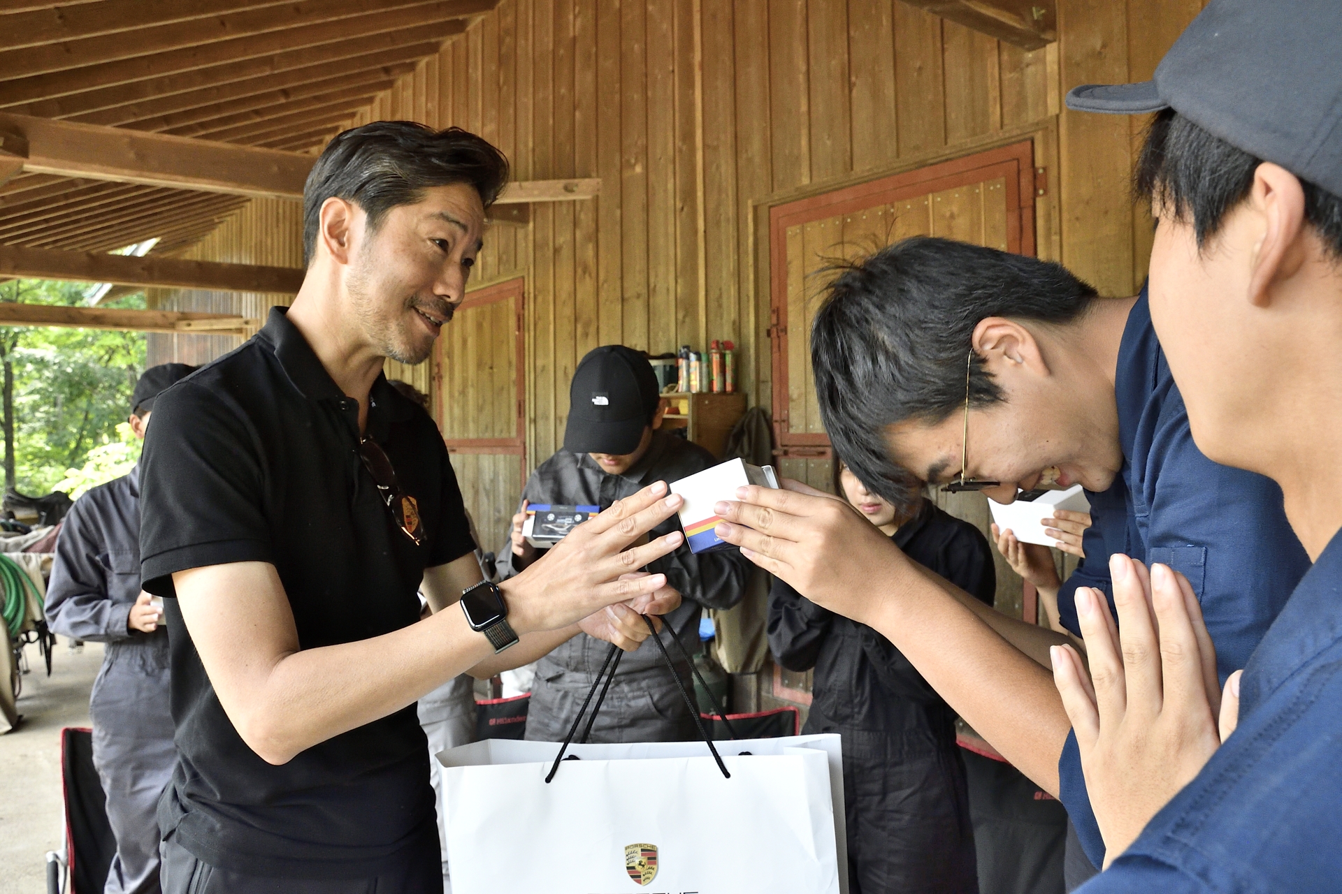 ポルシェジャパン株式会社 広報部 部長 黒岩真治さんから学生たちに911 ダカールのミニカーがプレゼント。さらに講師陣には911のロゴが入ったパーカーが手渡され、プログラムは終了となった