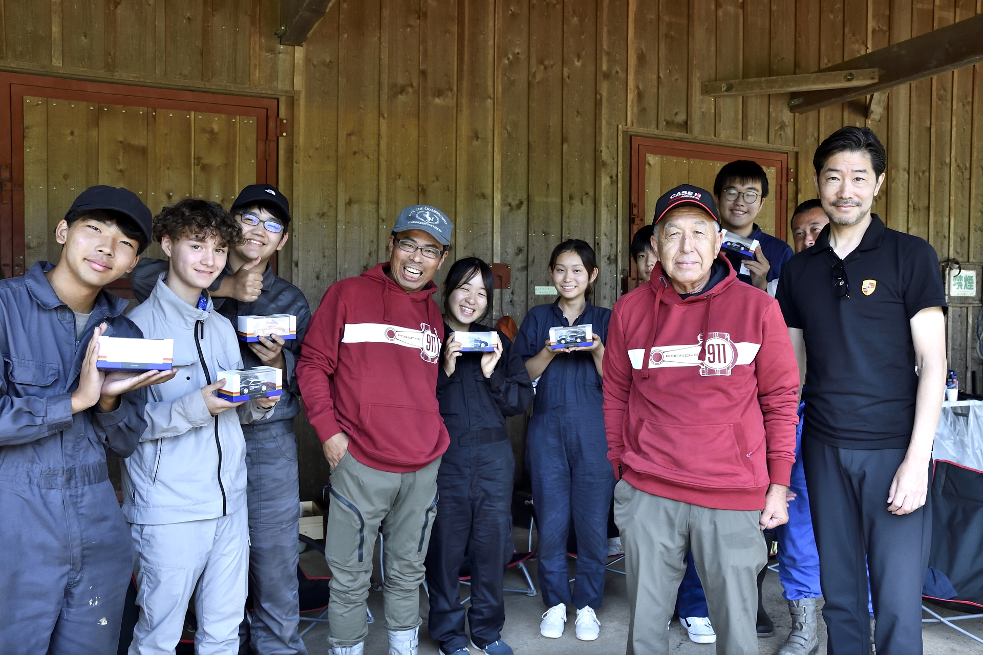 ポルシェジャパン株式会社 広報部 部長 黒岩真治さんから学生たちに911 ダカールのミニカーがプレゼント。さらに講師陣には911のロゴが入ったパーカーが手渡され、プログラムは終了となった
