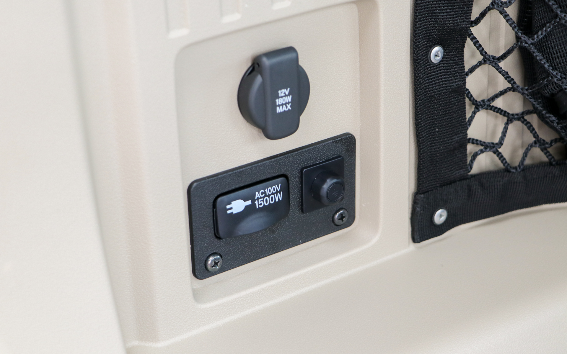 ラゲッジスペースの左後方にAC100V/1500Wのコンセントとアースポイントが追加される。上にある12V/180W上限のアクセサリーソケットは標準装備