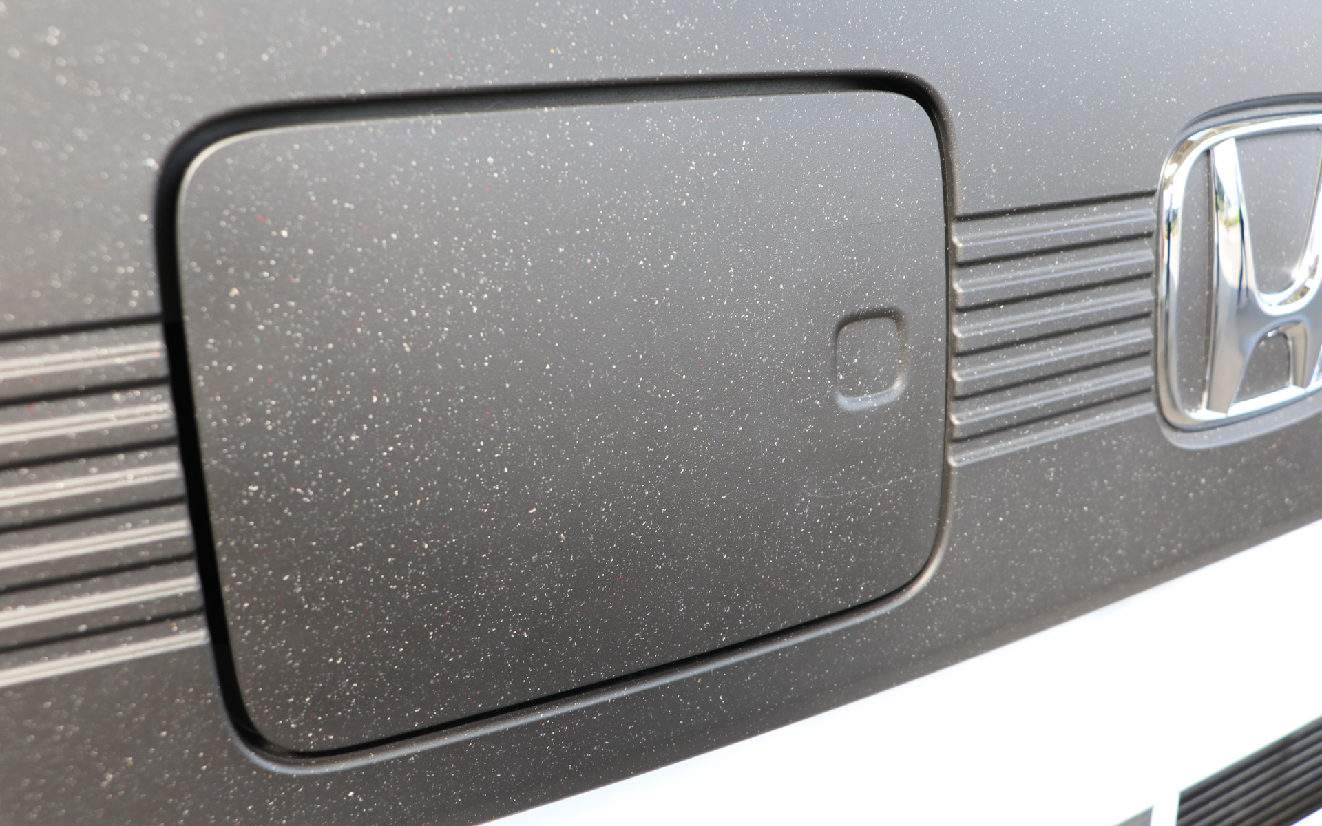 白い点々がバンパーの塗膜。パッと見はほとんど白だが、よく見ると銀、赤、青、黄などさまざまな色がある