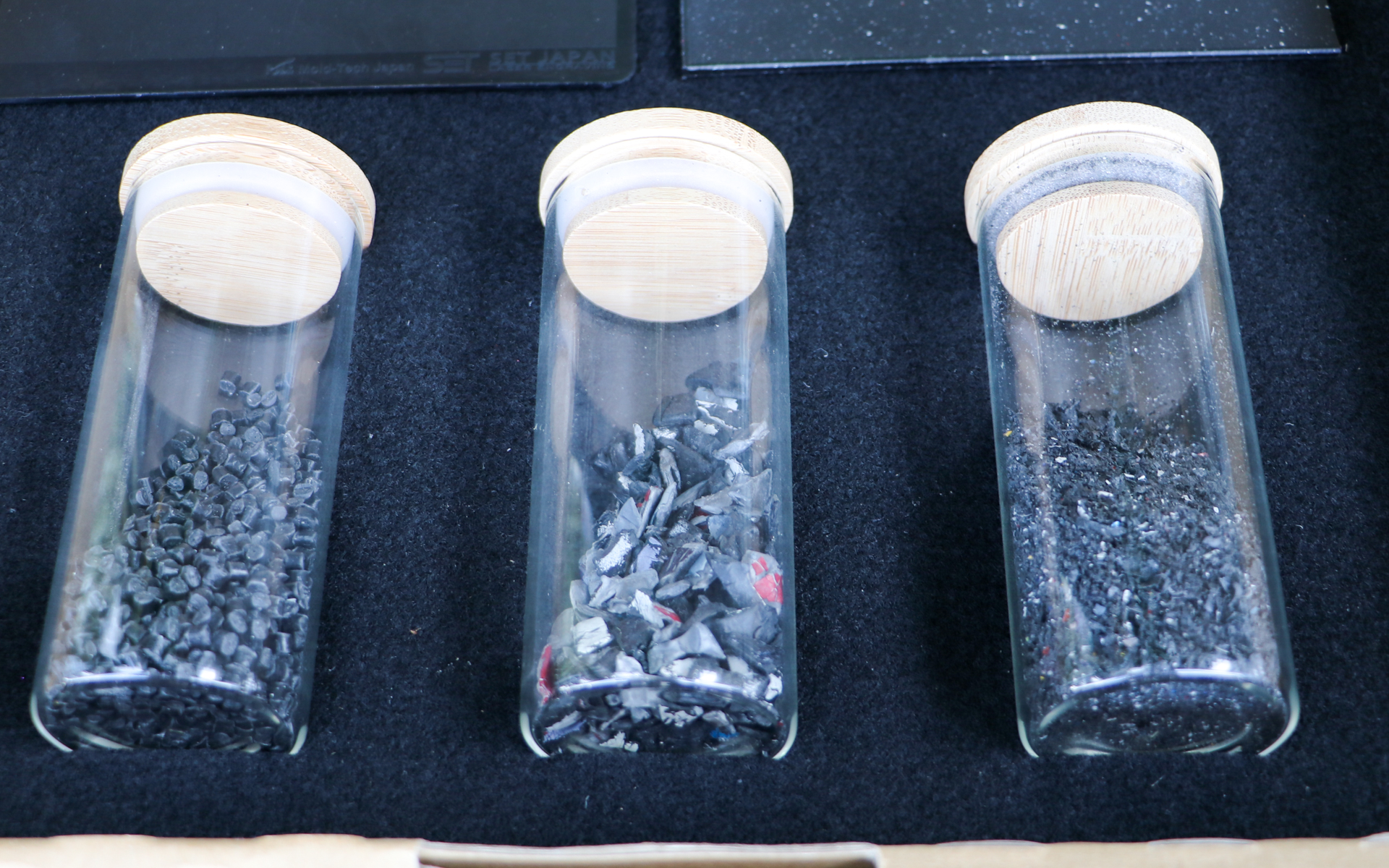 左が一般的なバンパー成形用の樹脂ペレットで塗膜などはきれいに除去されている材料。中央はホンダが自主的に回収して粉砕したバンパー粉砕材。右が今回フロントグリルなどに使用している塗膜の混ざったリサイクル材料