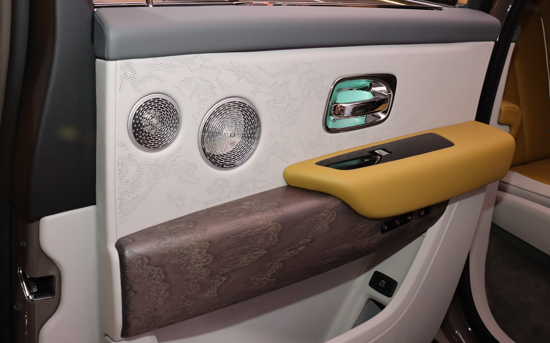 レザー表皮には大小2種類の穴で模様を描く「プレースド・パーフォレーション」を設定。木目パネルには天然オープンポア材「グレー・ステンド・アッシュ」を使用する