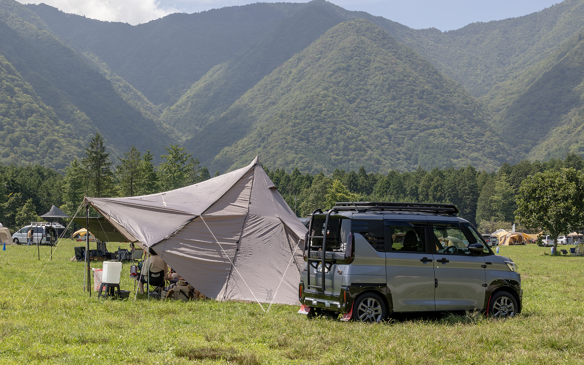 小さいながら多くの荷物が詰めるデリカミニもキャンプ向きのクルマ。人気の高いタープスペース付きのDODヤドカリテントと2ショット