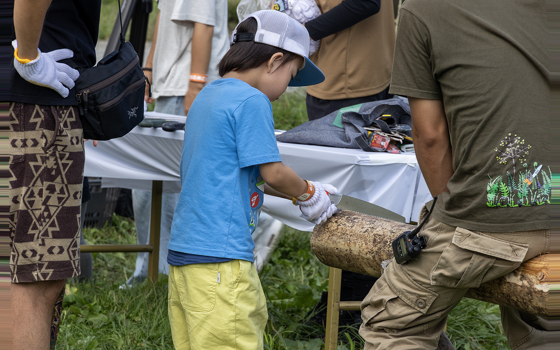 鋸を使っての丸太切り体験のコーナー。初めて鋸を使うという子どもも多かった