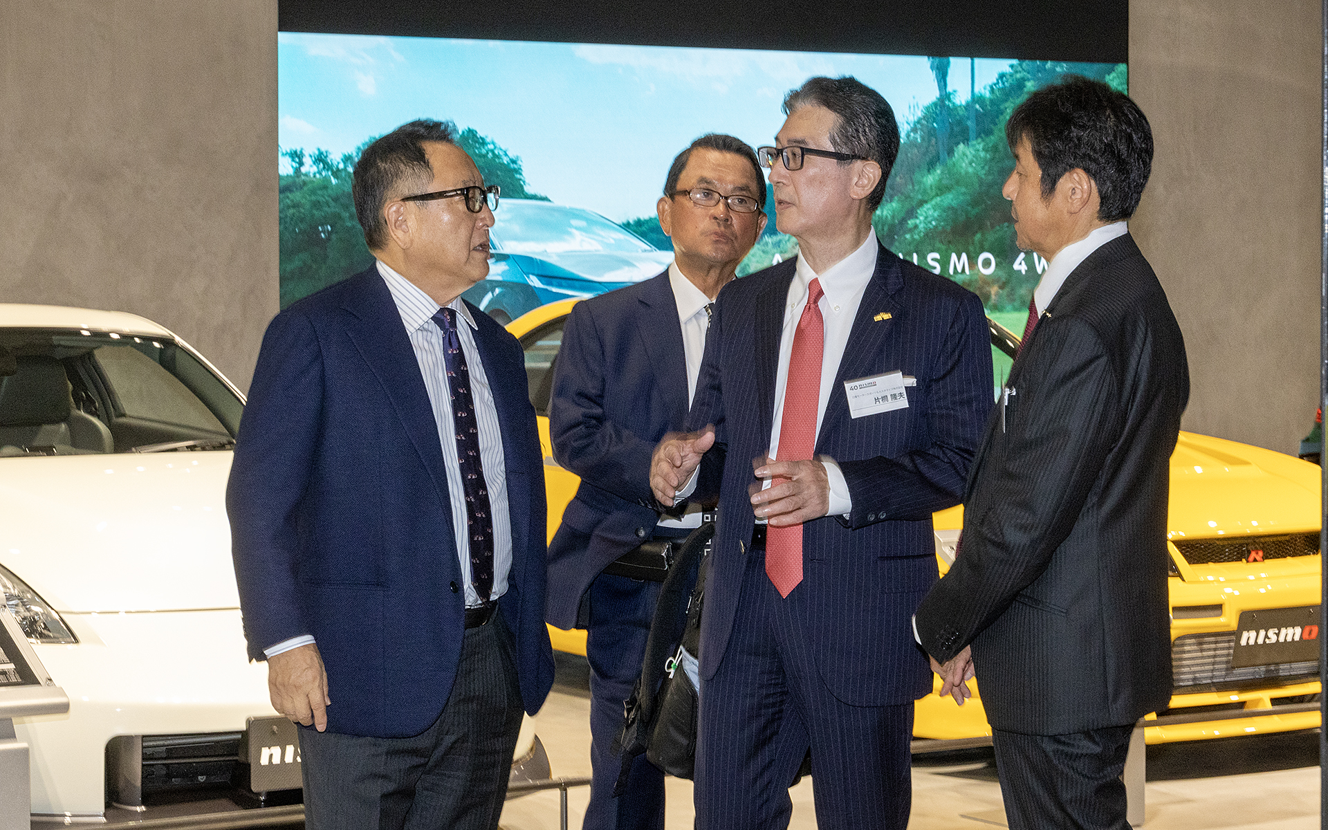 車両展示の場にゲストの豊田章男氏が登場。ニッサンモータースポーツ＆カスタマイズ株式会社 代表取締役社長兼最高経営責任者 片桐隆夫氏より説明を受けていた