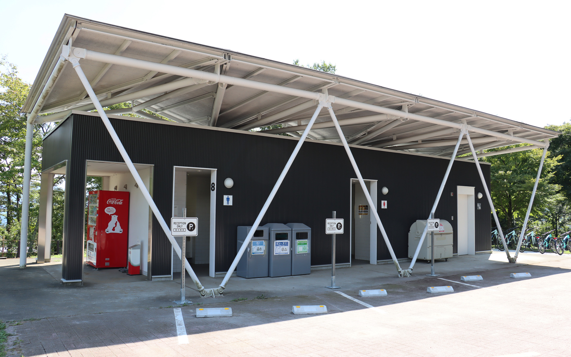 受付用の駐車スペースと並んで共有トイレと自販機コーナーを用意