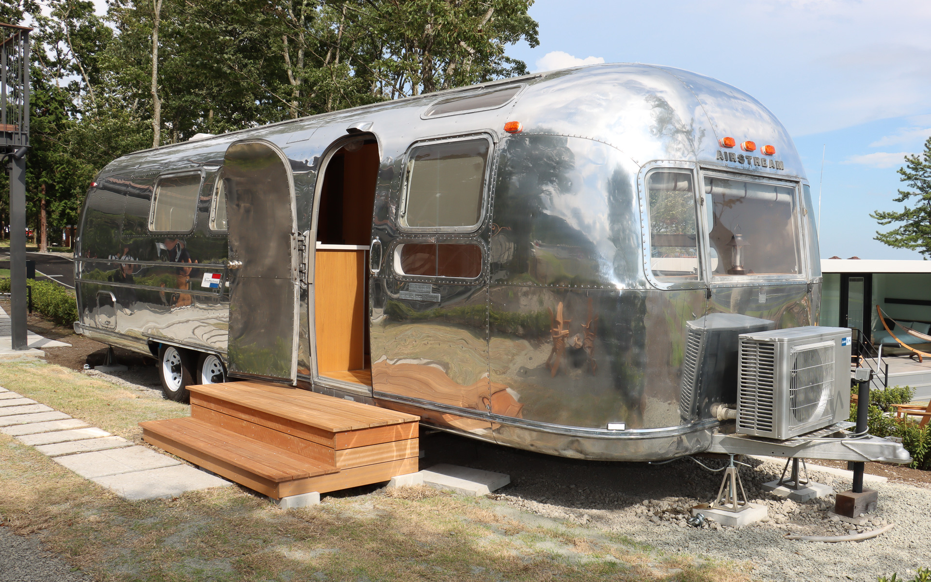 宿泊施設として用意された1970年製のキャンピングトレーラー「エアストリーム sovereign」。生産当時の美しさを蘇らせるべく、アルミ製のボディパネルにバフ掛けを行なっているが、側面や後方に刻まれたへこみなどは車両の歴史としてそのままにしている、また、ブレーキランプやウインカーなども修理して、夜間に点灯させて楽しめるようにした