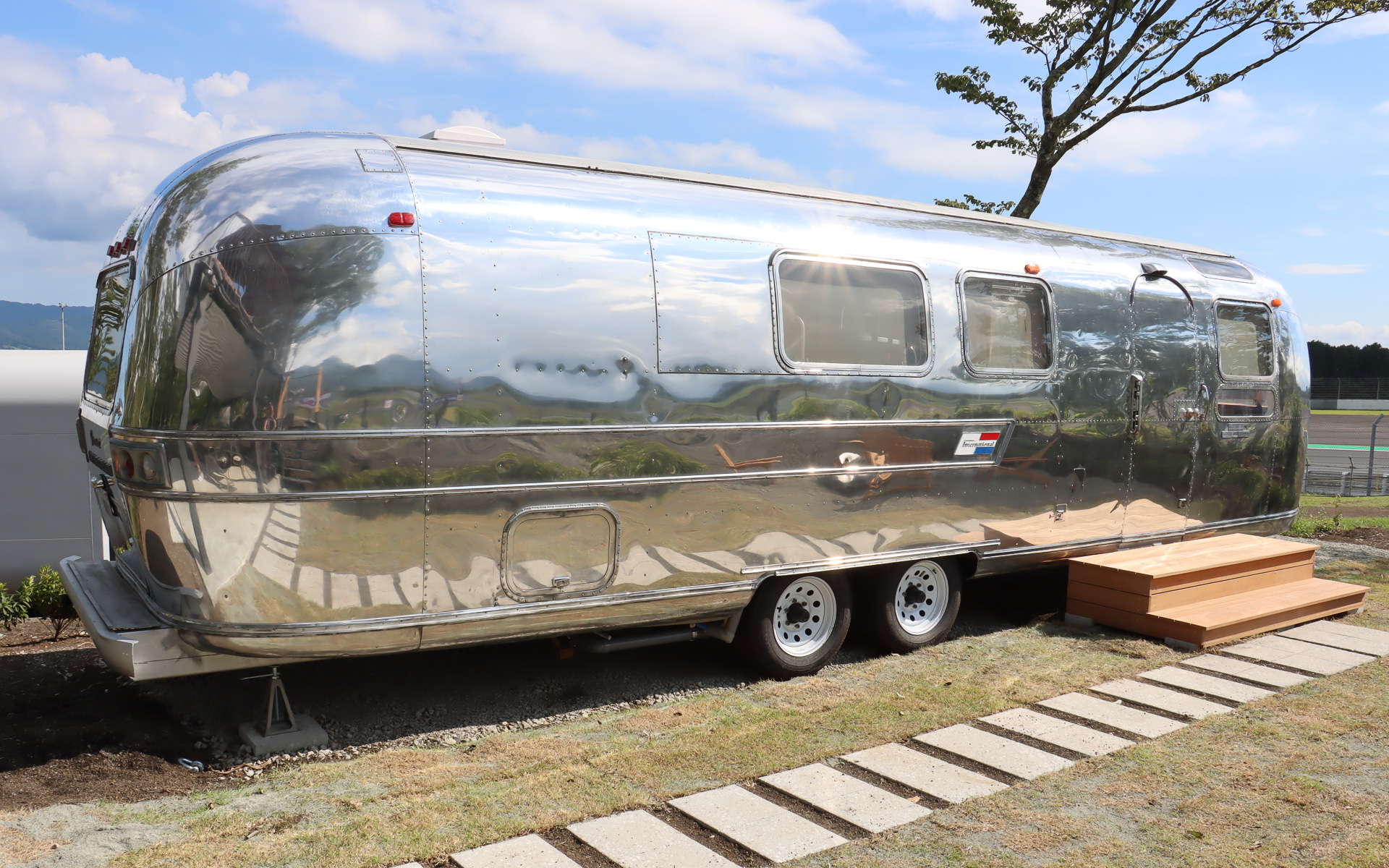 宿泊施設として用意された1970年製のキャンピングトレーラー「エアストリーム sovereign」。生産当時の美しさを蘇らせるべく、アルミ製のボディパネルにバフ掛けを行なっているが、側面や後方に刻まれたへこみなどは車両の歴史としてそのままにしている、また、ブレーキランプやウインカーなども修理して、夜間に点灯させて楽しめるようにした