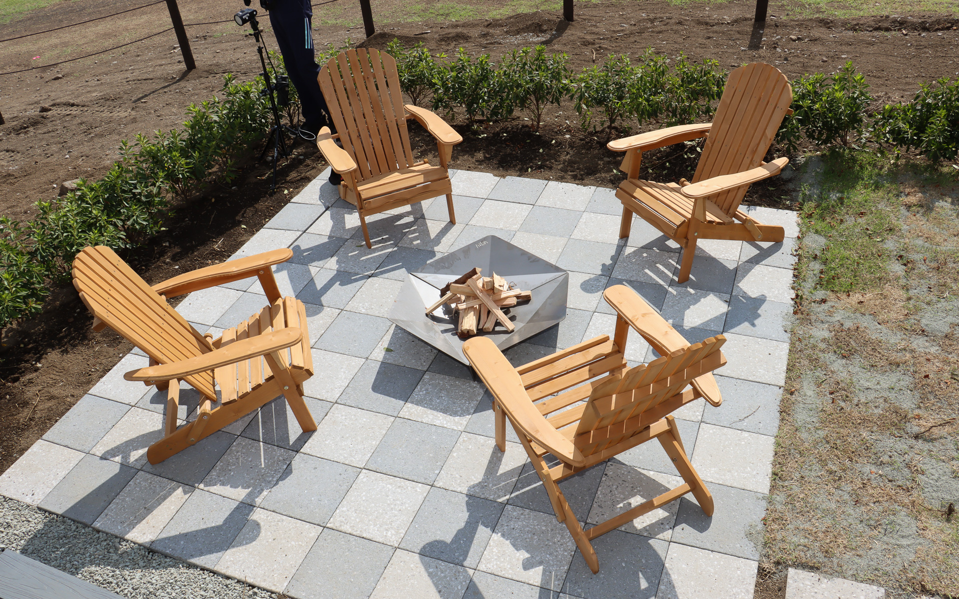 大型の焚火台とウッドチェアを屋外に配置