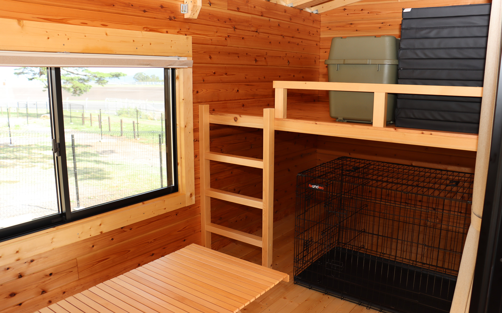 ロフトスペースを備えるトレーラーコテージ内に犬用のケージも設置