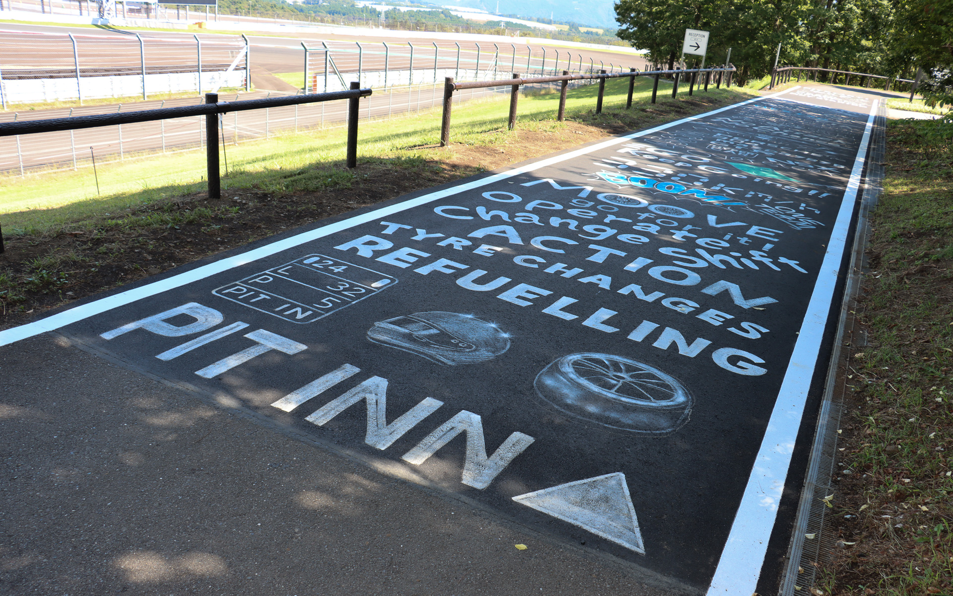 受付エリアに続く車道にはレーシングイメージをアピールするペイントが施されている