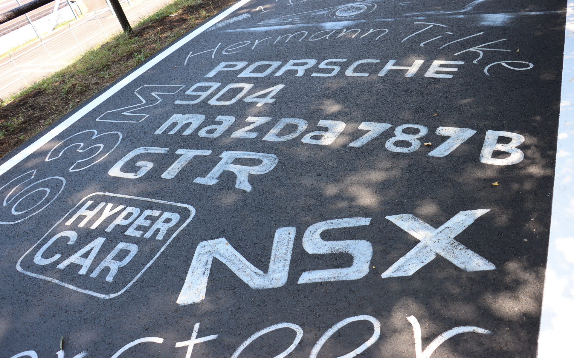 受付エリアに続く車道にはレーシングイメージをアピールするペイントが施されている