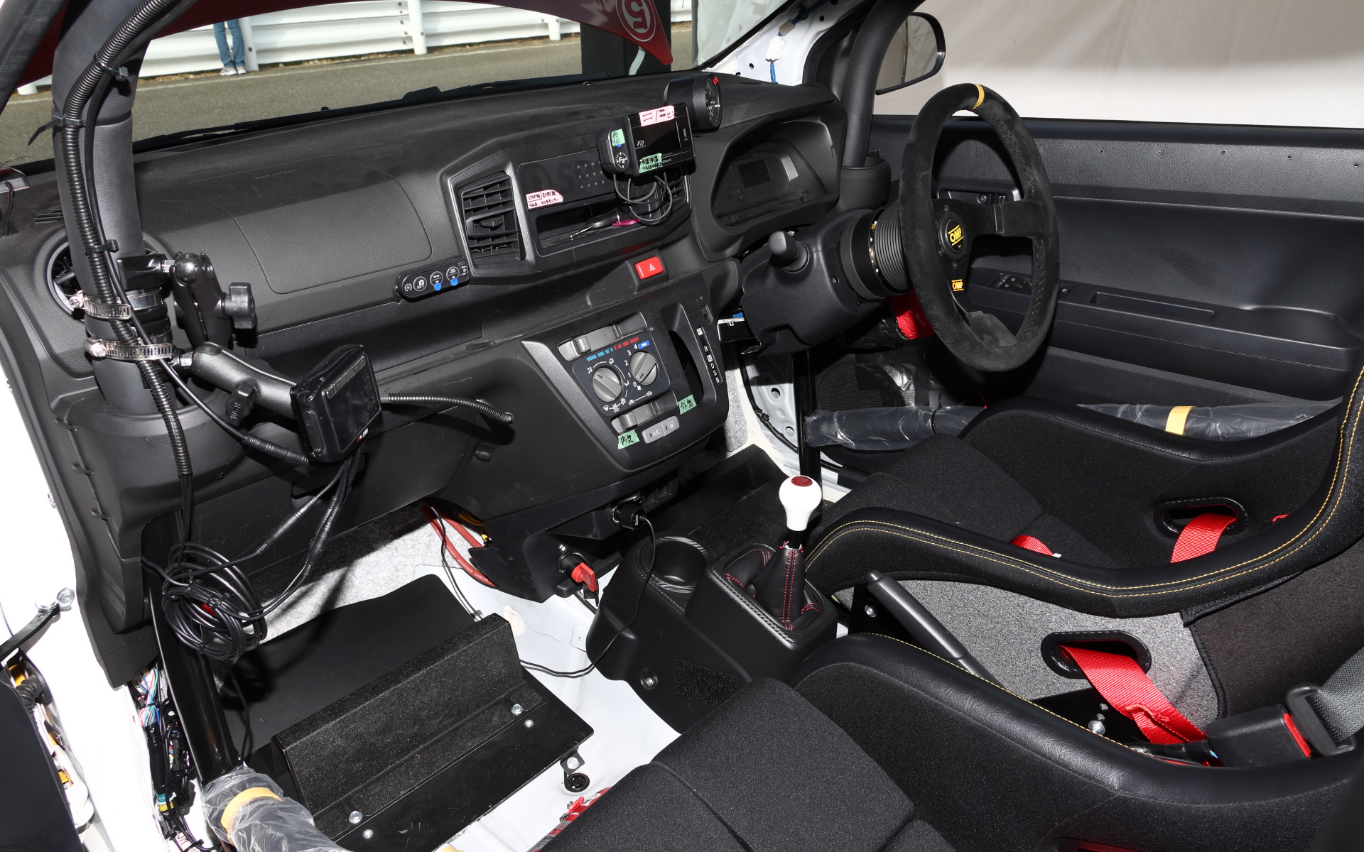 5速MTに換装されたミラ イース ターボのインテリア。ロールバーやバケットシートを備えるが、ダッシュボードやドアトリムあたりの雰囲気はノーマルと変わらない