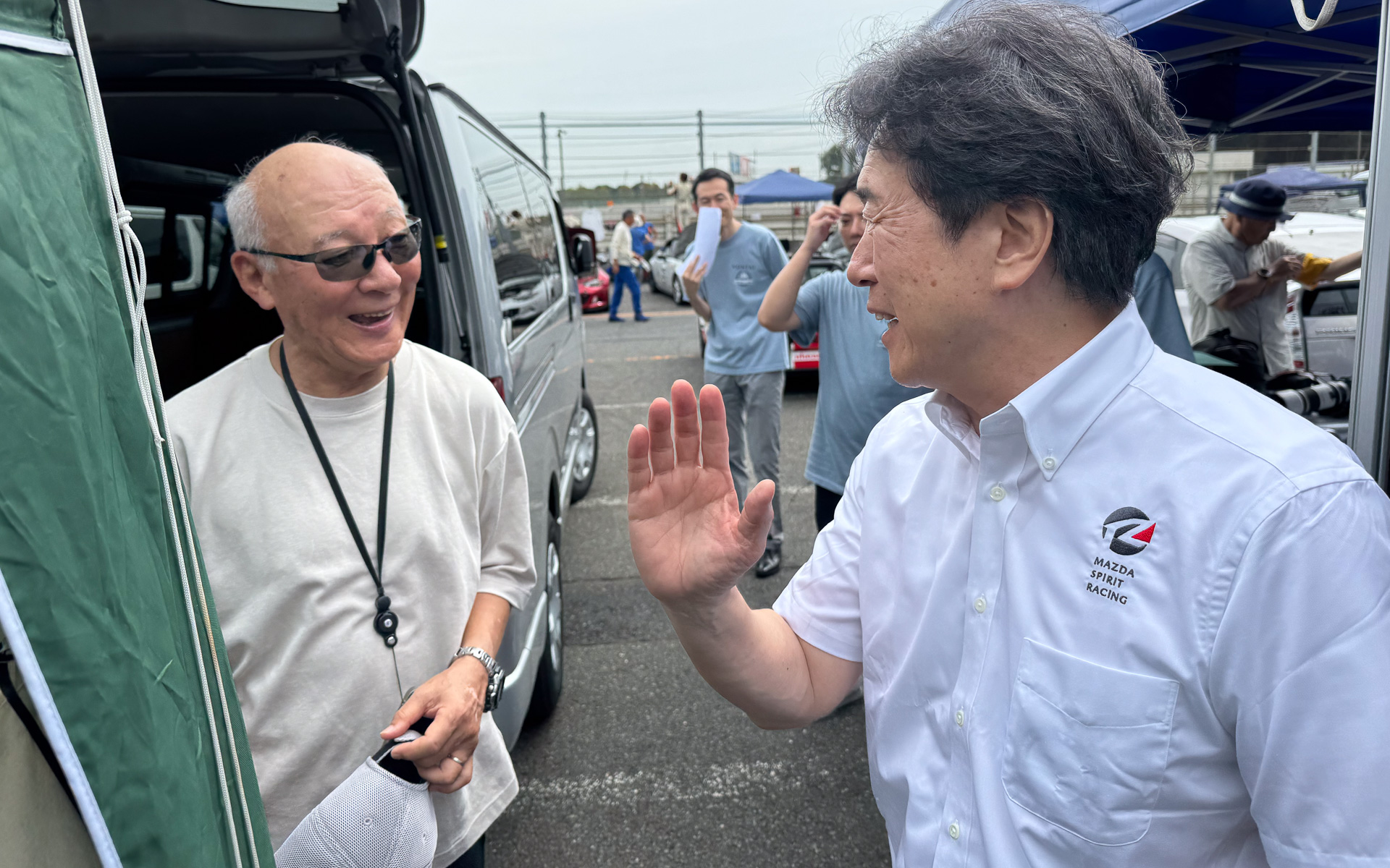 各チームを激励に訪れるマツダ株式会社 代表取締役社長 毛籠勝弘氏（右）。Car Watchチームのドライバーである日下部保雄氏（左）と歓談中