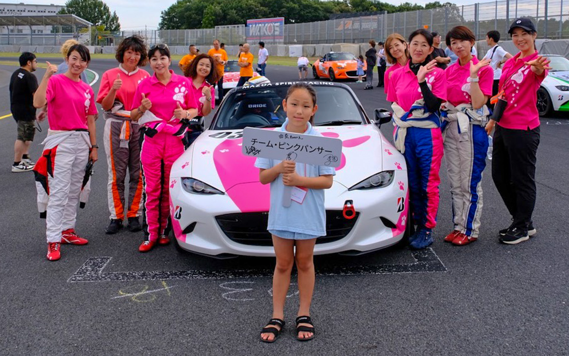 決勝レースのグリッドは17番。グリッドガールを務めてくれたのは、去年と同じ由奈ちゃんでした。左から藤島知子、いのまり、竹岡圭、いつもお手伝いに来てくれるゆかりちゃん、宮村さん、池田美穂、谷口いづみ、まるも亜希子。わいわいと賑やかなチーム・ピンクパンサーです。写真提供：野々 肇