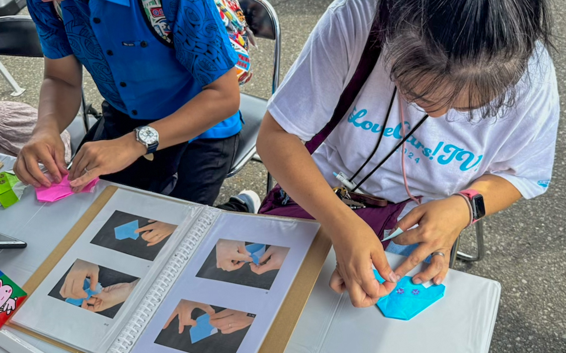 昨年からはじまった、来場者の皆さんに楽しんでもらう「ふれあいタイム」。各チームが知恵を絞っていろんなコンテンツを用意してるんですが、チーム・ピンクパンサーでは「ロードスター折り紙を折ろう！」ということで折り紙や肉球シールを用意。ただ、これが思ったよりずっと難しく、チームメンバーが誰ひとりまともに折れないという緊急事態が発生（笑）。そこで急遽、ゼッケン3にちなんでストップウォッチで3秒を当て、ガチャを引けるという「タイムアタックガチャ」もやり、ファミリーに楽しんでもらいました