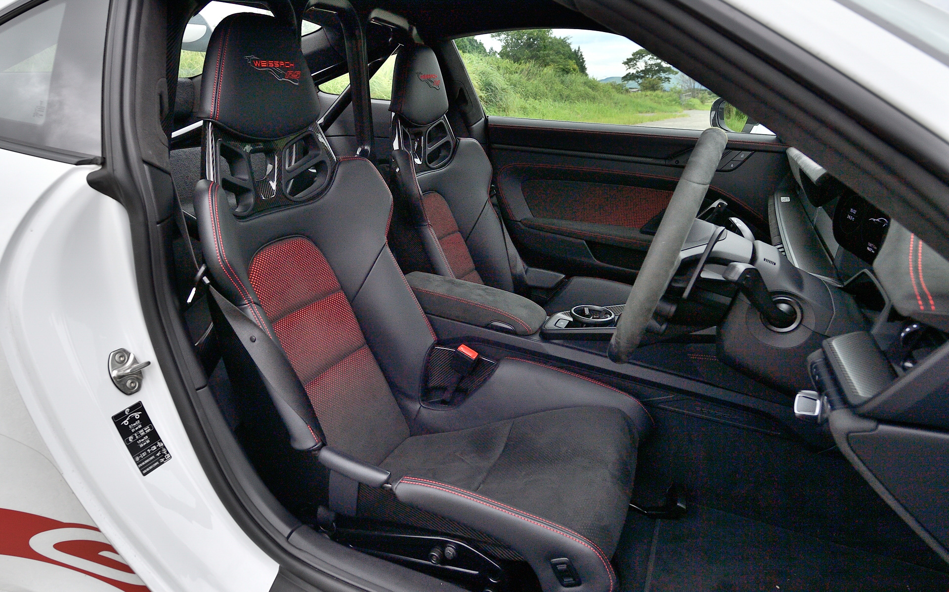 インテリアではカーボンファイバー製のフルバケットシートを採用するなど、レーシーな仕上がり。ステアリング下側にあるボタンでドライブモードやPASM、ESC（エレクトロニック・スタビリティ・コントロール）、TC（トラクション・コントロール）、PTV（ポルシェ トルク ベクタリング）などを変更できる