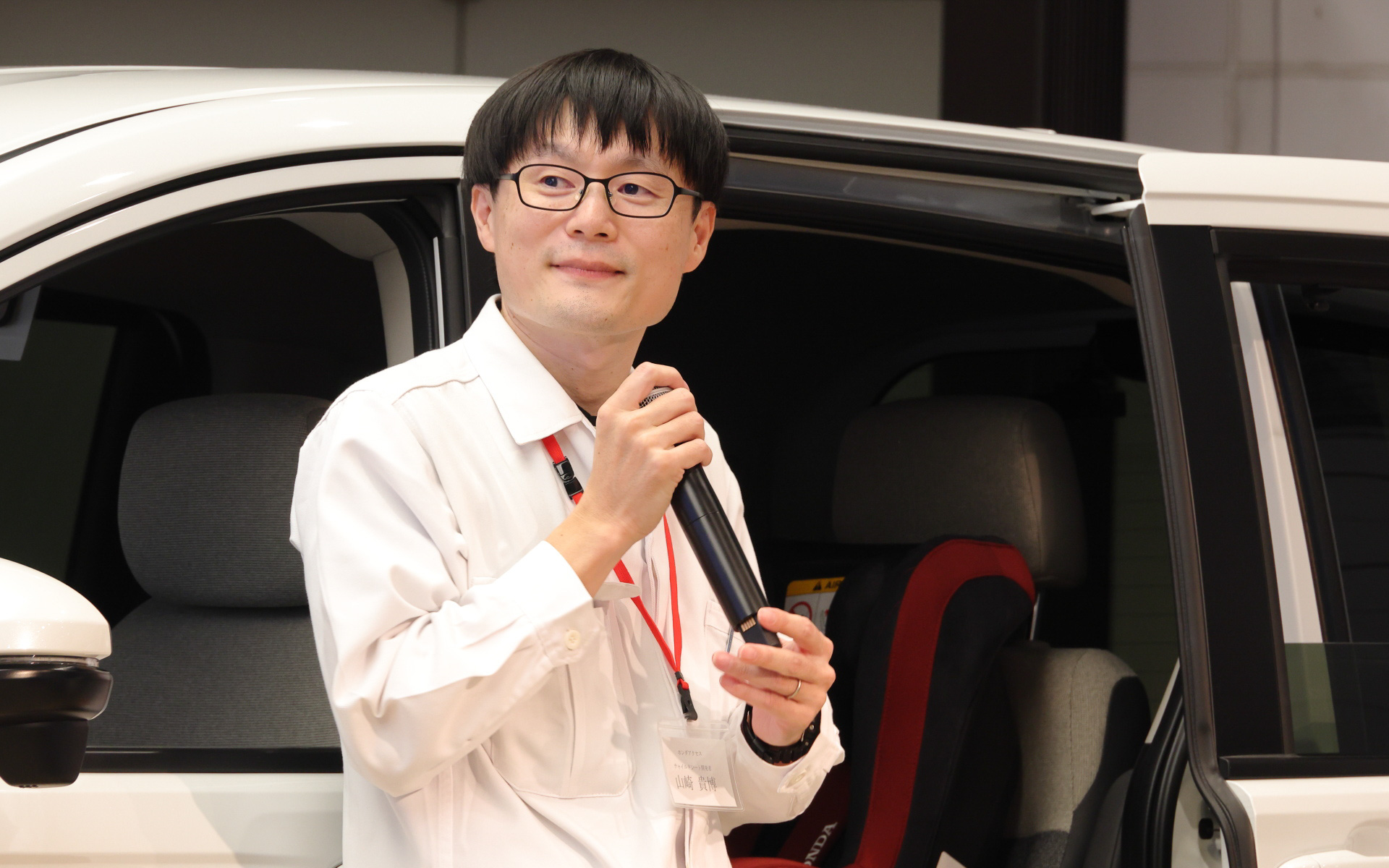 みずからチャイルドシートの装着を実演した開発者の山崎貴博氏