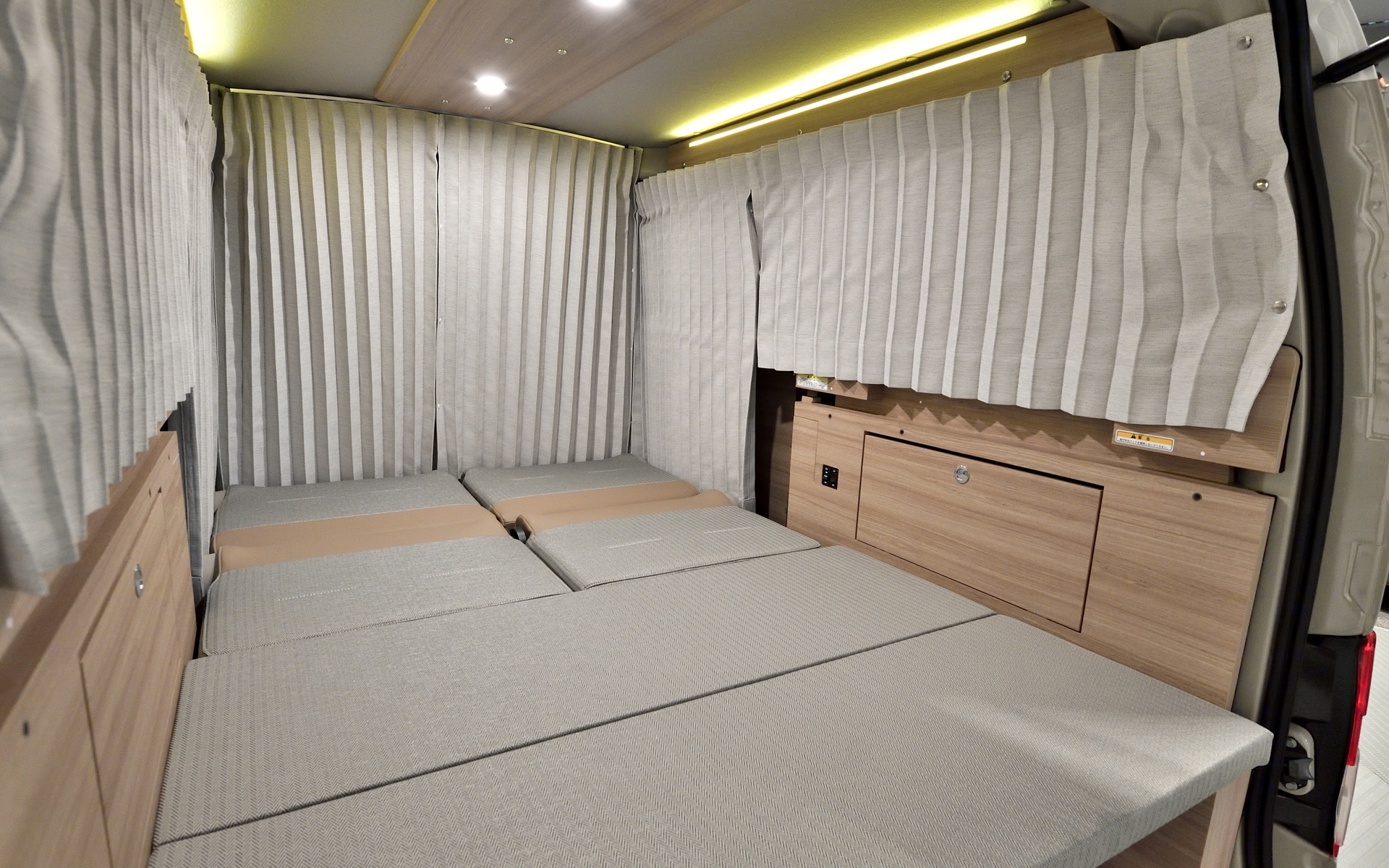 自由に使えるラゲッジスペース。写真はフルフラット状態。カーテンは架装オプション設定