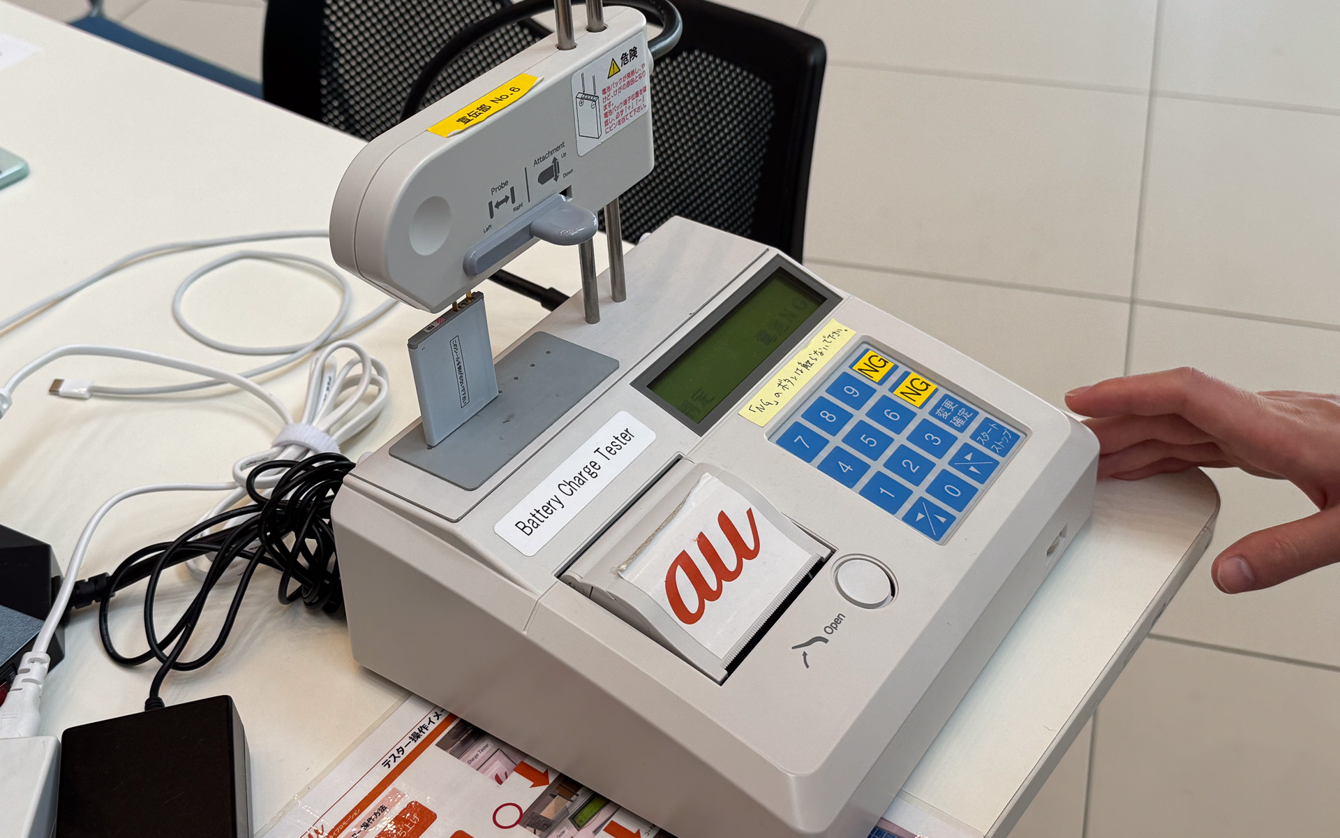 auショップで使われていた充電装置を活用して、ガラケーの再充電を行なっている