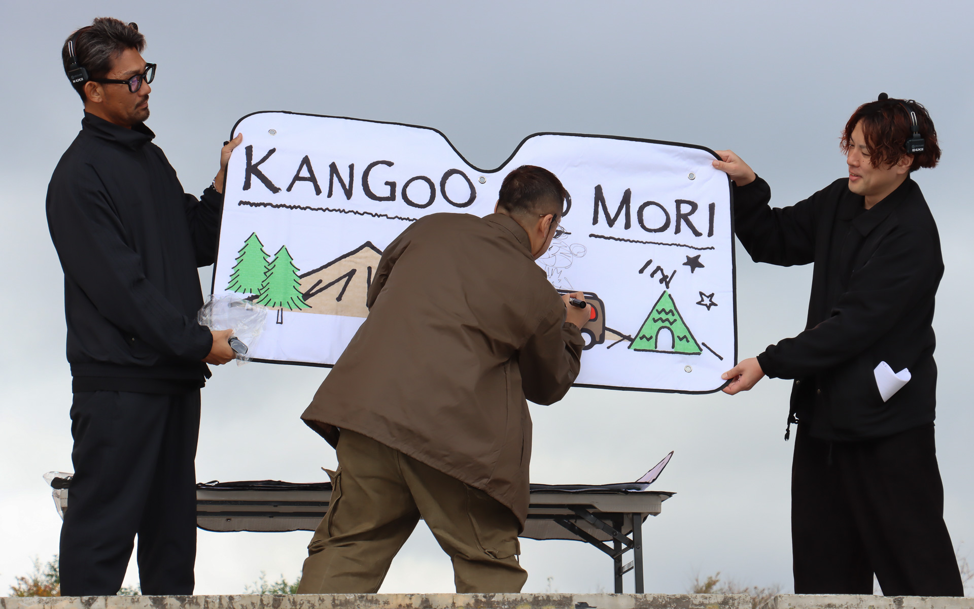 「カングーの森」オリジナルサンシェードに、安田団長がその場でサインやイラストを描いてプレゼント。じゃんけん勝負では、安田団長のファンなら絶対に勝てる仕組みが用意されていた