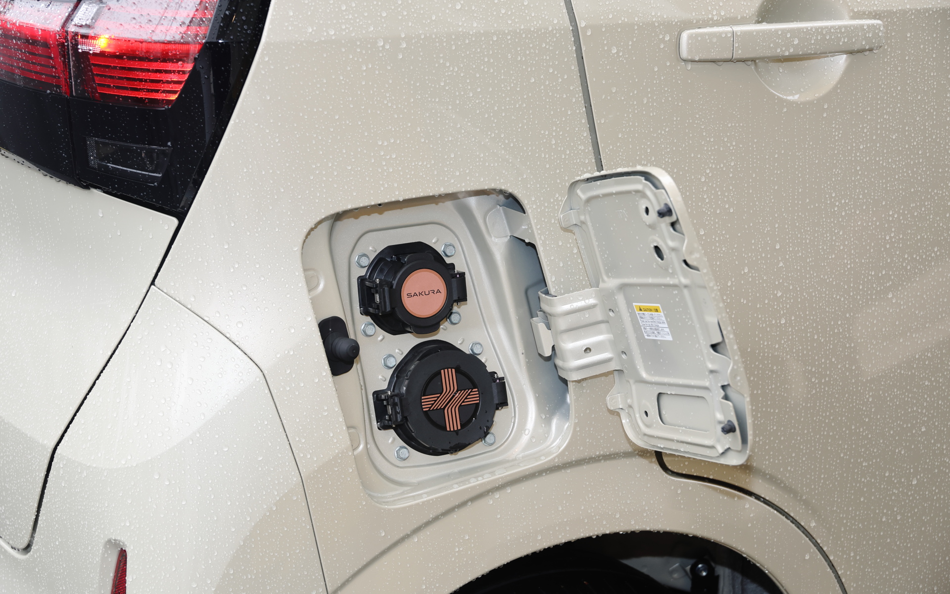 サクラは充電ポートを右側後方に配置。上が普通充電用で下が急速充電用（CHAdeMO）のポート