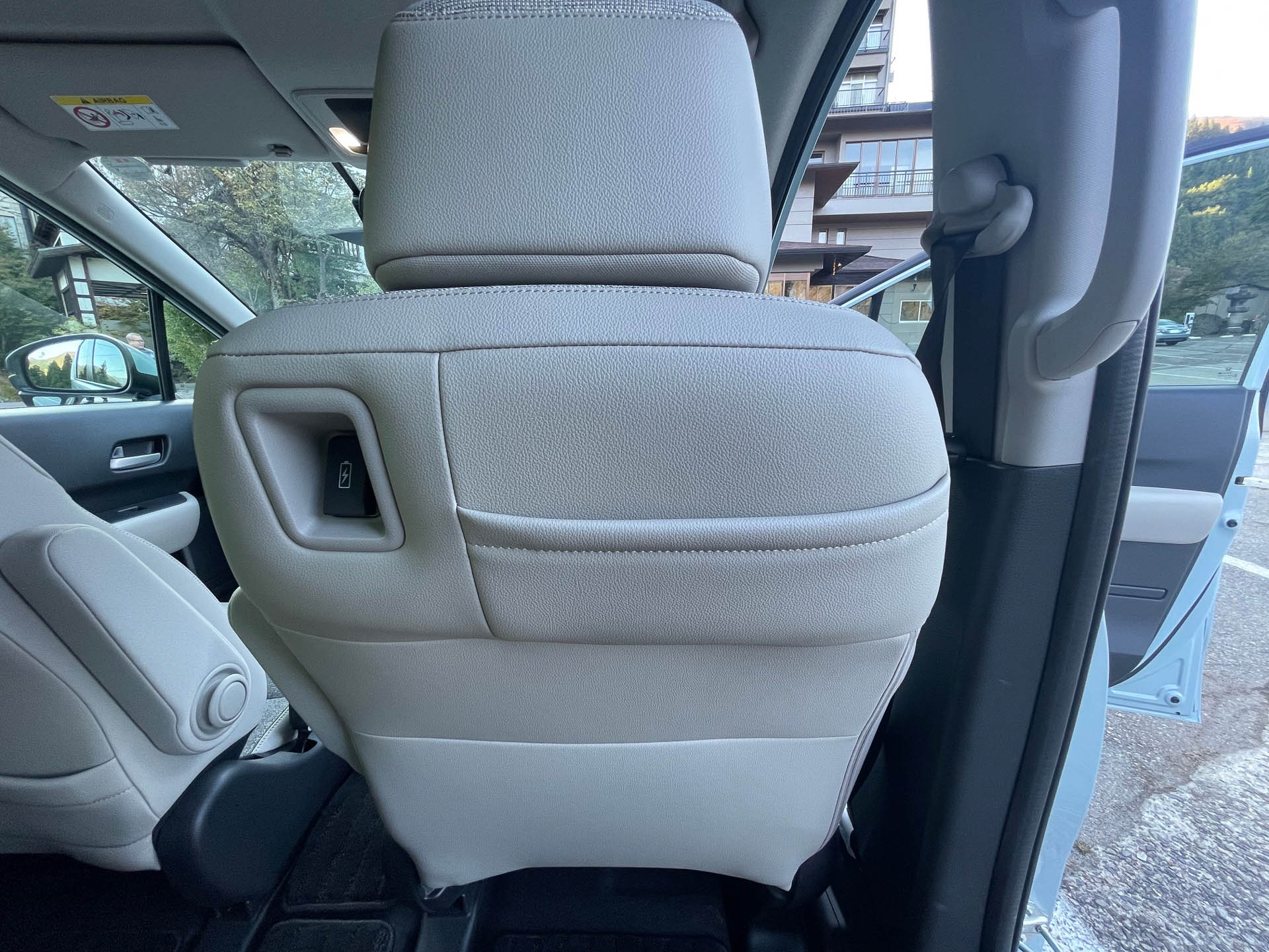 2列目から眺めたフロントシート。上方を絞ったデザインで前方視界もひらけて明るい。シートバックはスマフォ入れなど少ない空間を有効活用しているのは軽譲り