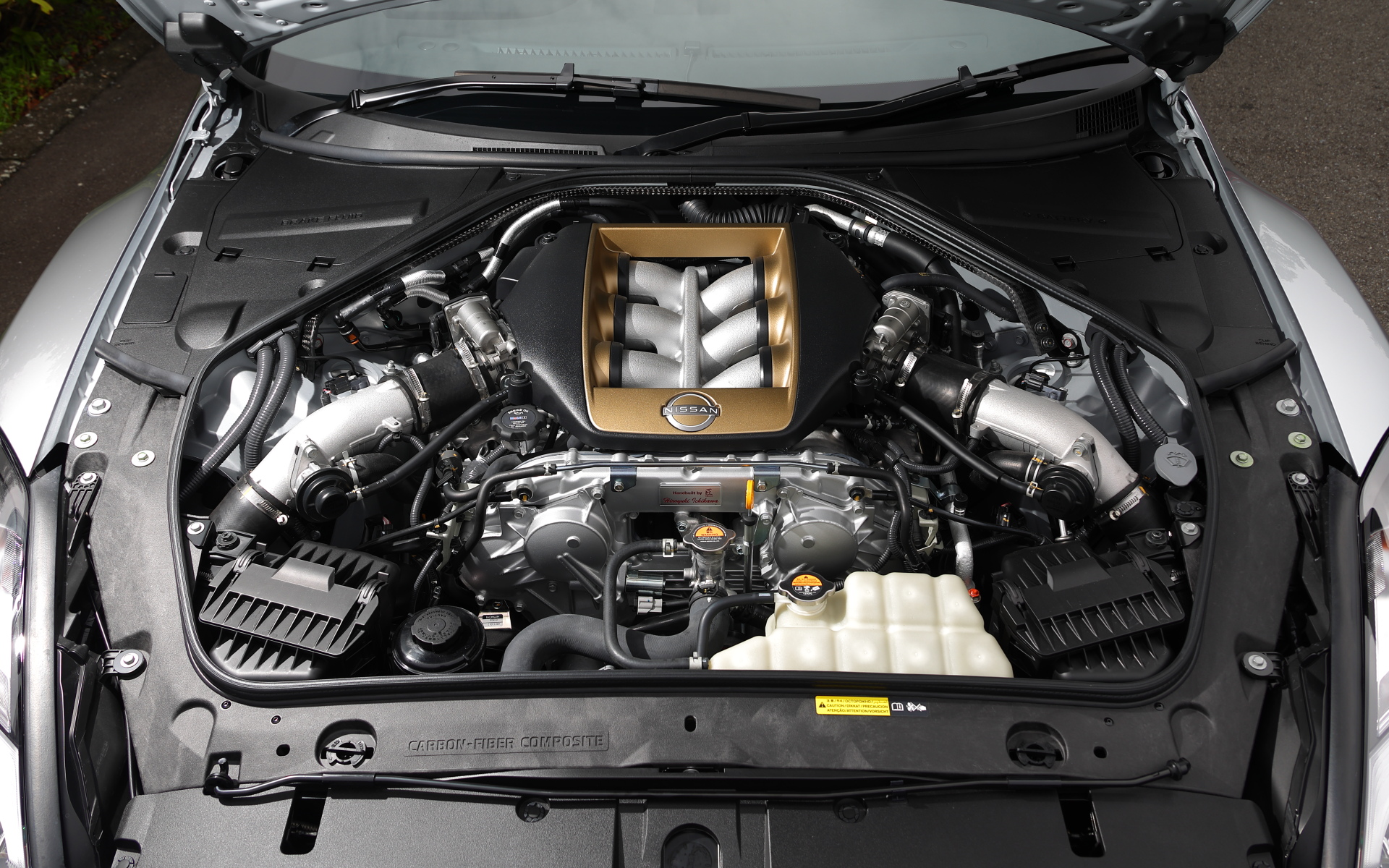 ゴールドのT-spec専用カバーが配されたV型6気筒3.8リッターツインターボエンジン「VR38DETT」は、95.5×88.4mm（ボア×ストローク）で圧縮比は9.0。最高出力419kW（570PS）/6800rpm、最大トルク637Nm/3300-5800rpmを発生。そこに6速DCT（デュアルクラッチトランスミッション）が組み合わせられる。WLTCモードでの燃費は7.8km/L、ガソリンタンクの容量は74L