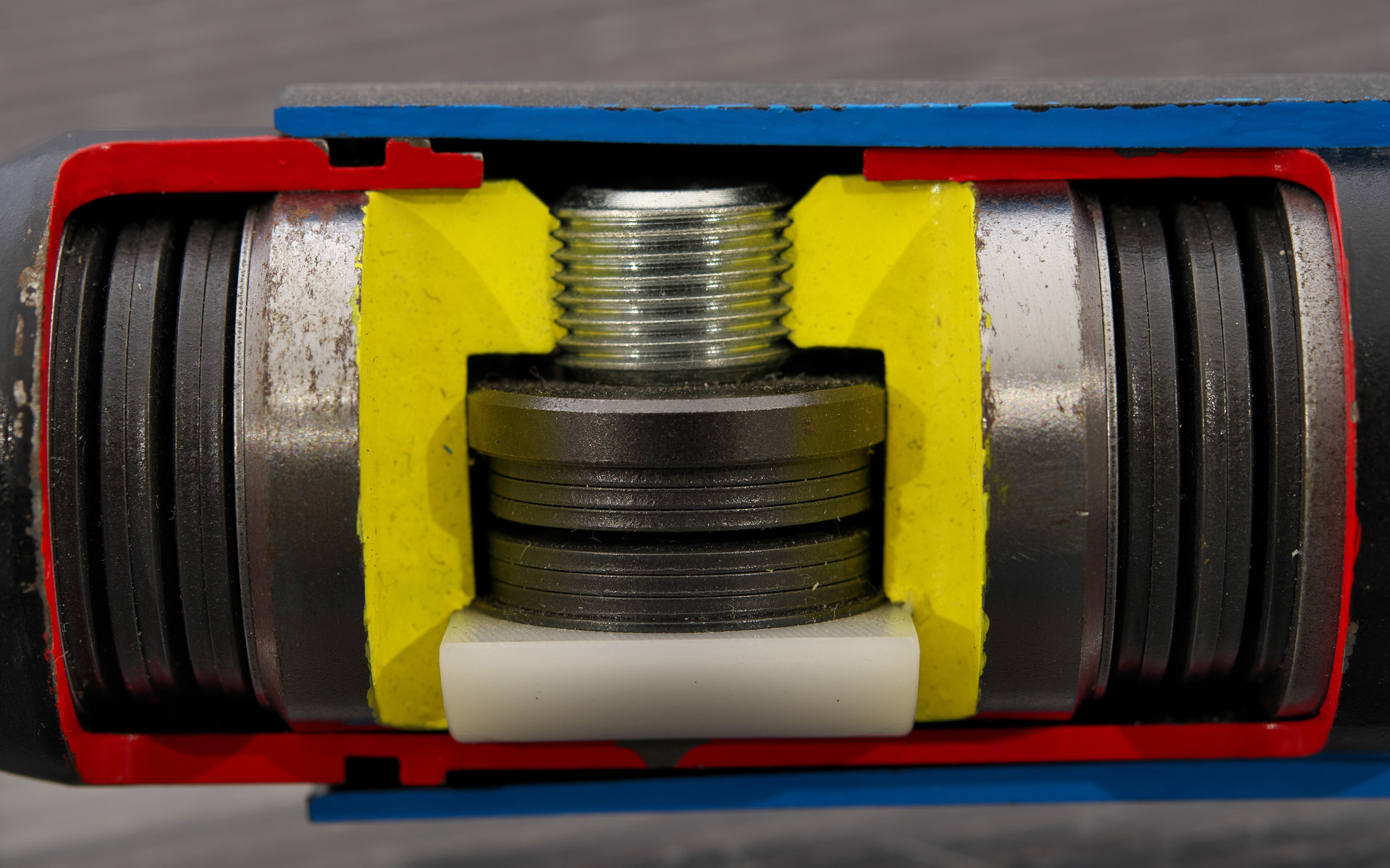 大きな入力に対しては横方向に搭載しているスプリング機構で、微振動は摩擦機構（白いPOM樹脂が擦れることで発生する力）でいなす構造。スプリング機構に使用するバネは2種類の硬さがあり、用途で使い分けているそうだ