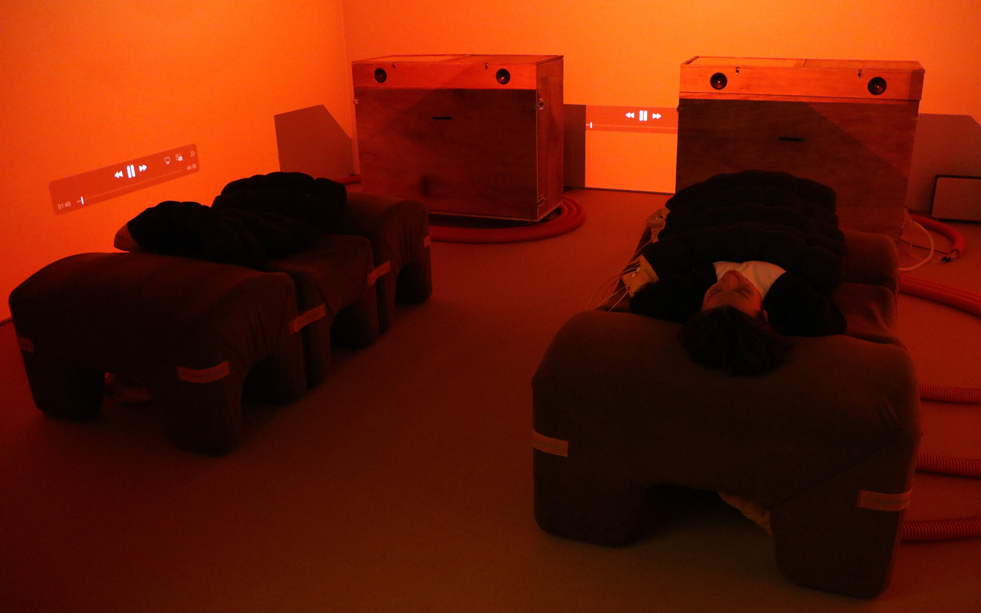 Morphはエア圧で動くため、作動中はコンプレッサーの低い音を発するが、実環境ではBGMが流れるため耳に付くことはない（Morphに寝ているのはモデル役の運営スタッフ）