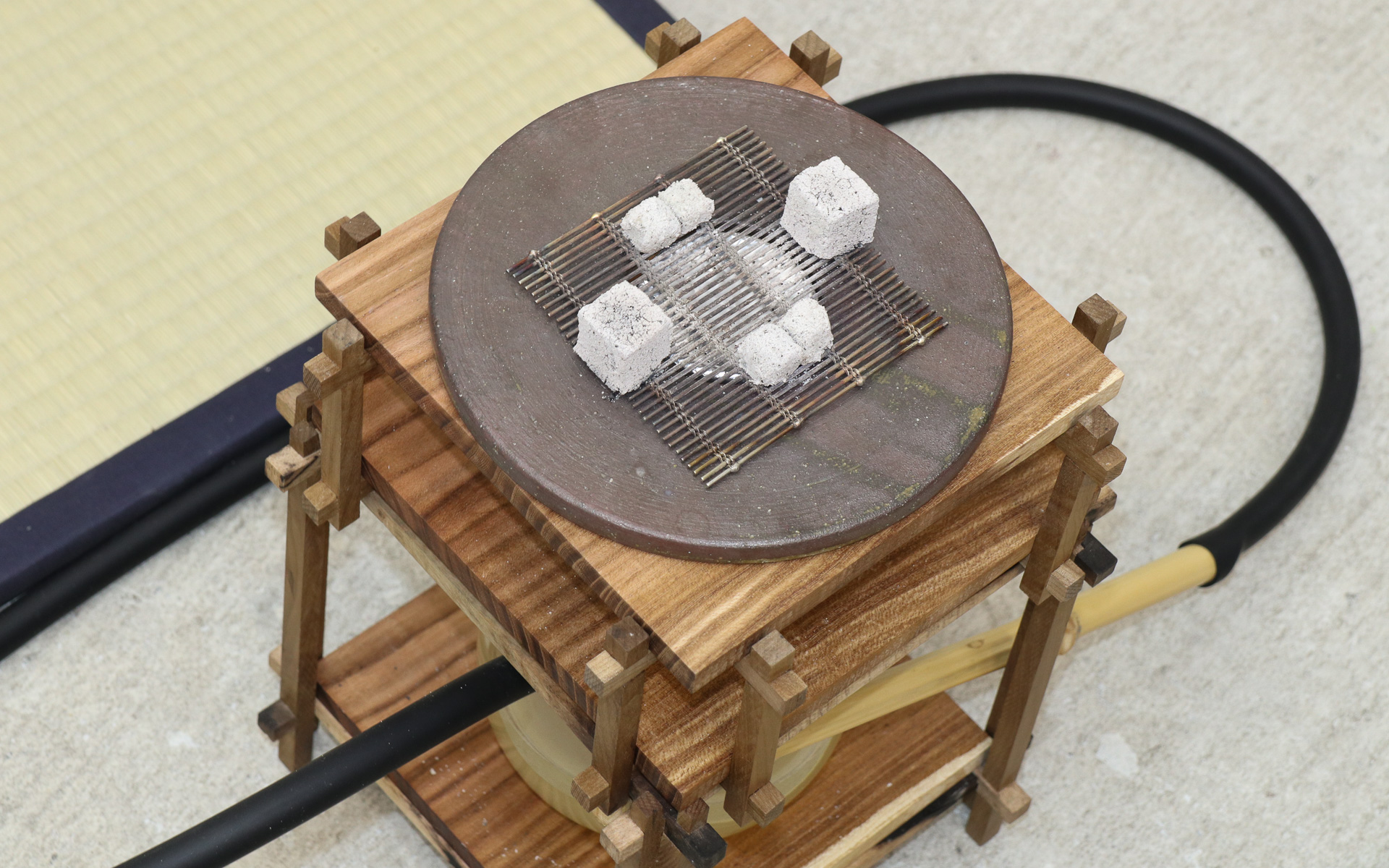 木材を使って組み上げられ、和のテイストを盛り込んだ茶香用のシェーシャ本体。シーシャボウル内の日本茶が炭火で加熱され、フィルターとなるお茶で濾過された煙を吸い込む