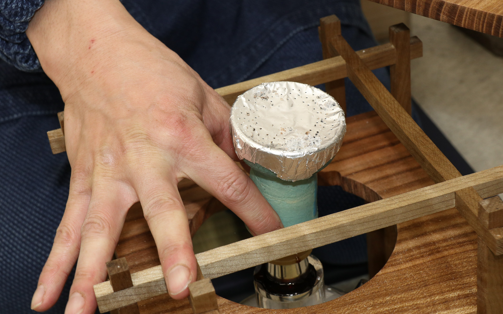 木材を使って組み上げられ、和のテイストを盛り込んだ茶香用のシェーシャ本体。シーシャボウル内の日本茶が炭火で加熱され、フィルターとなるお茶で濾過された煙を吸い込む