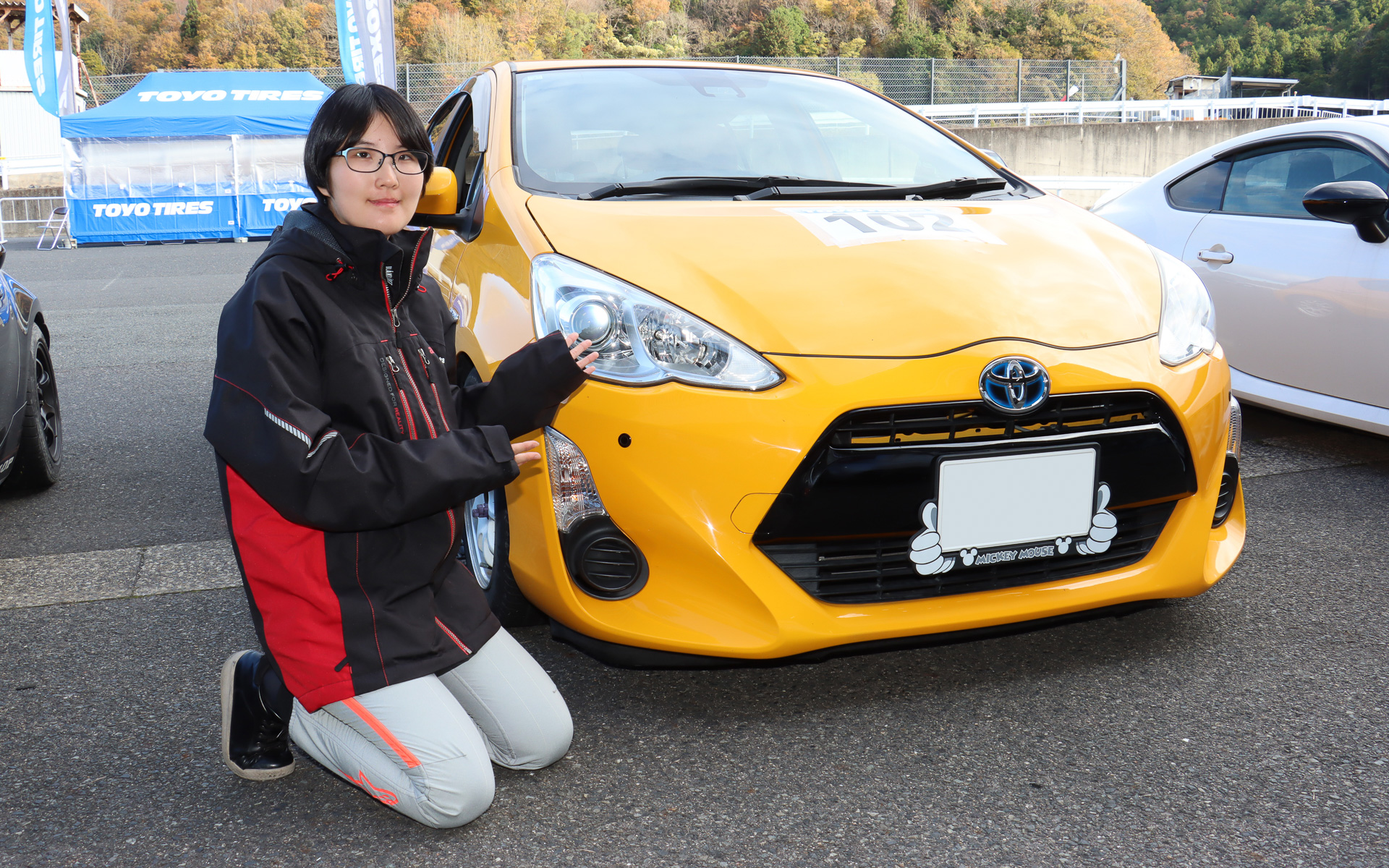 舞さんと愛車のトヨタ・アクア。目立つ黄色いボディカラーとかっこいいスタイルがお気に入りという