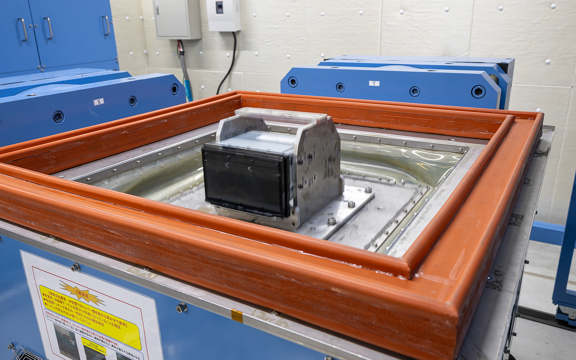 悪路を走行したときのシミュレーションができる振動テスト用の試験機。かなり激しい振動だったが、その状態でまる１日動かしっぱなしで試験する。取材時は電源が入っていなかったが、電源を入れた状態でも同様の試験を行なっている