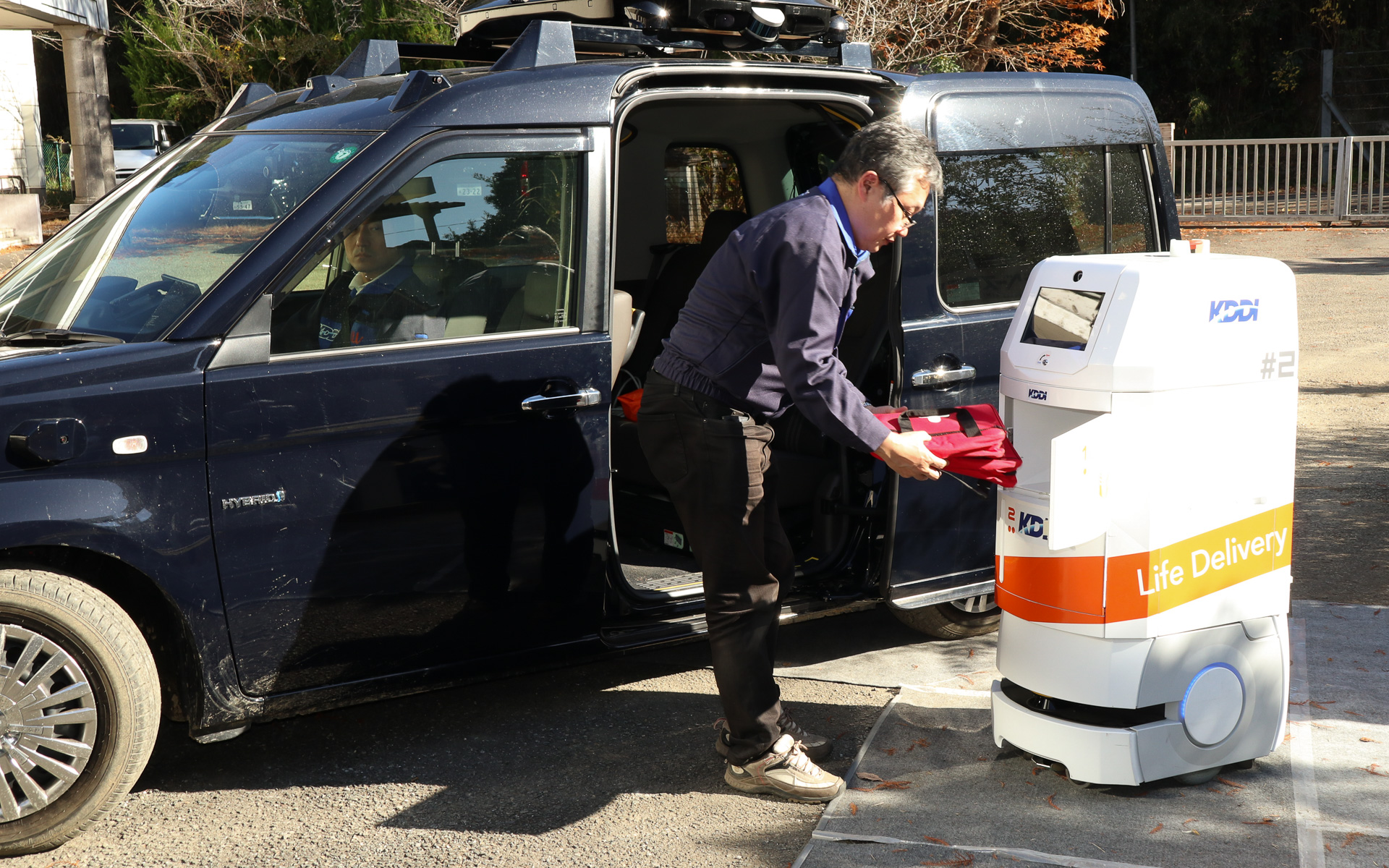 配送ロボットの収納ボックスから自動運転車の後部座席に荷物を移動