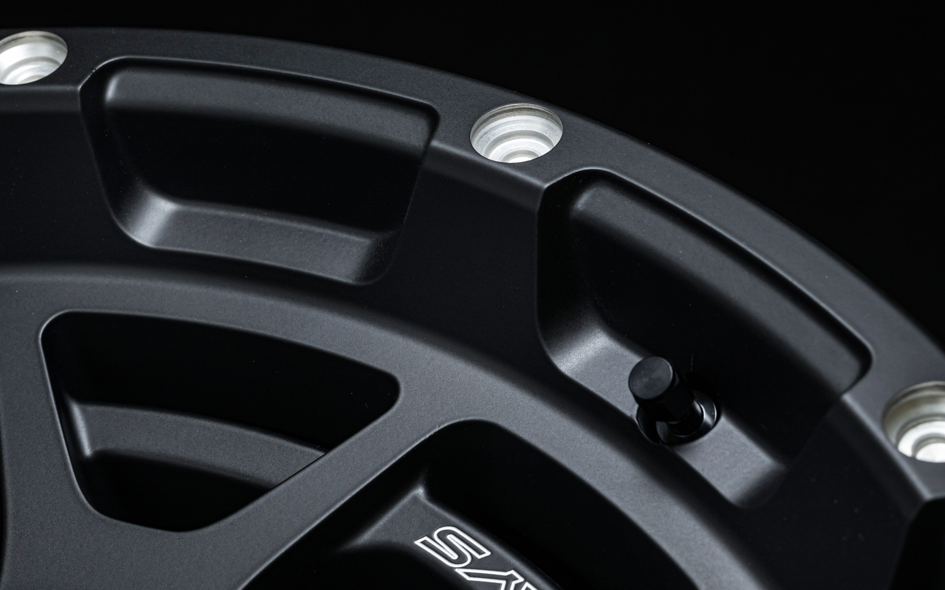 リムにはドリルド加工でピアスボルトのように見える円の削り込みを入れている