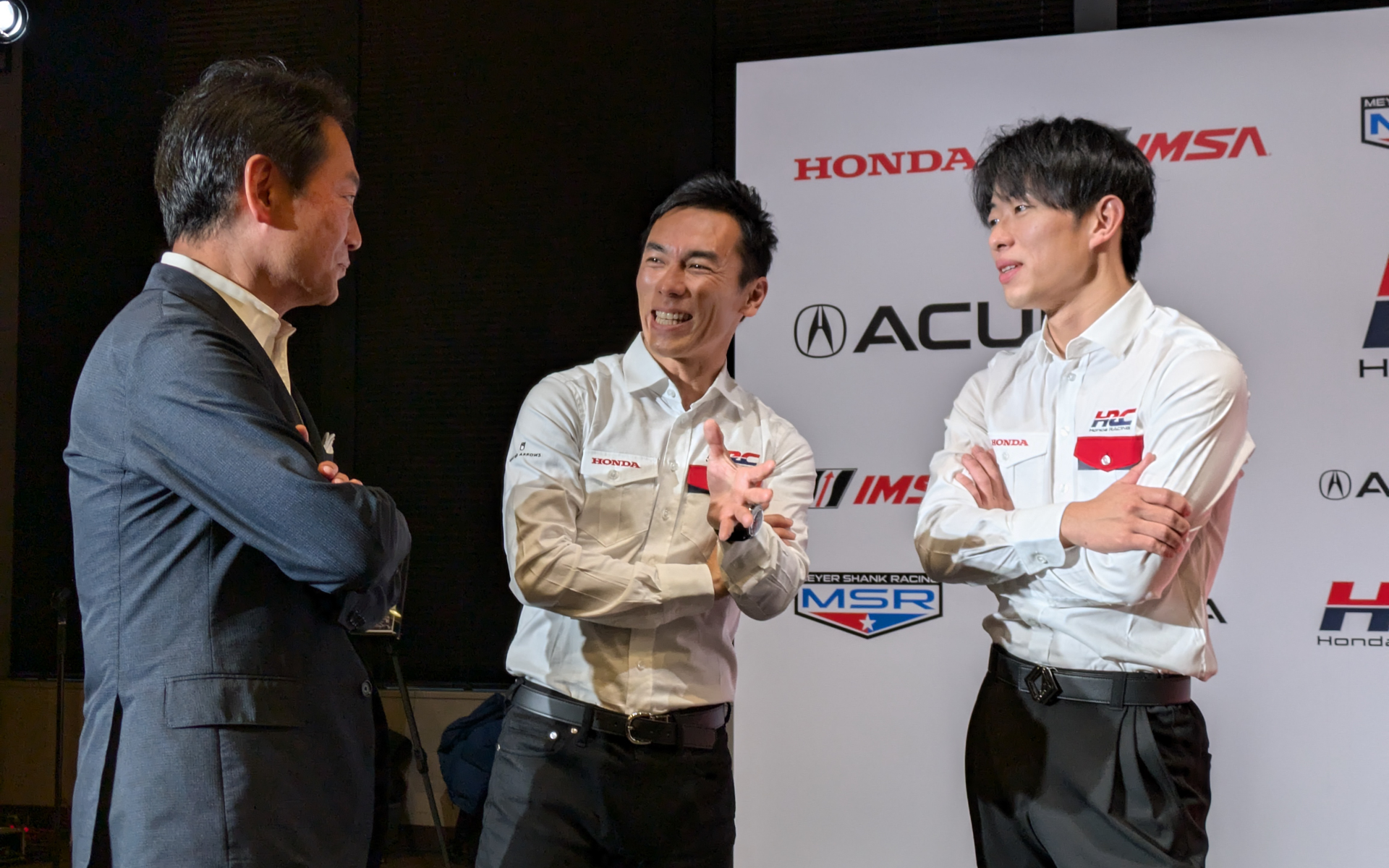 会場で談笑していたHRC 代表取締役社長 渡辺康治氏（左）、HRC エグゼクティブアドバイザー 佐藤琢磨氏（中）、太田格之進選手（右）