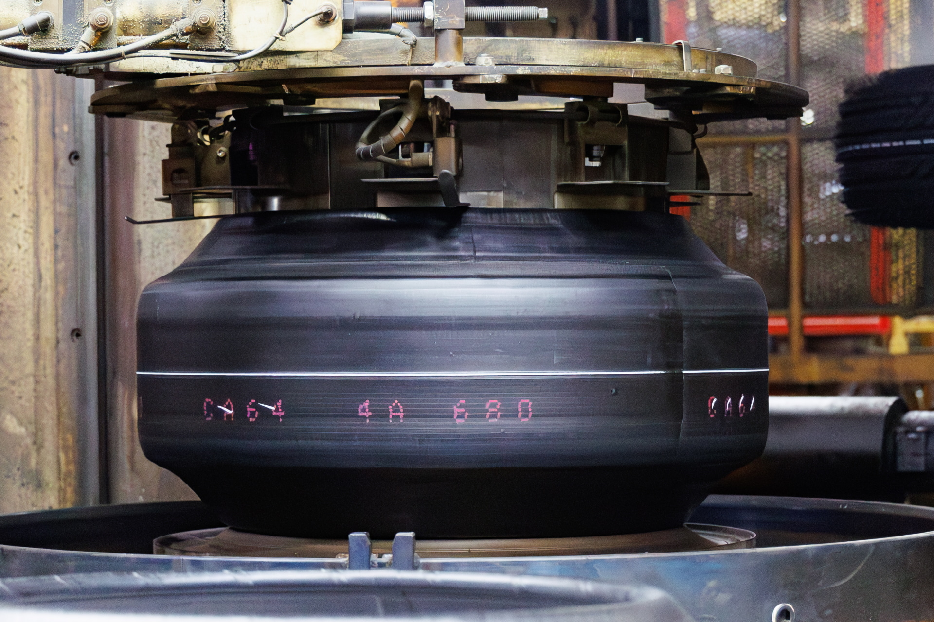 加硫とは生タイヤを大型の釜に入れ、熱と圧を加えてタイヤとしての形状を完成させる工程。これは生タイヤの状態