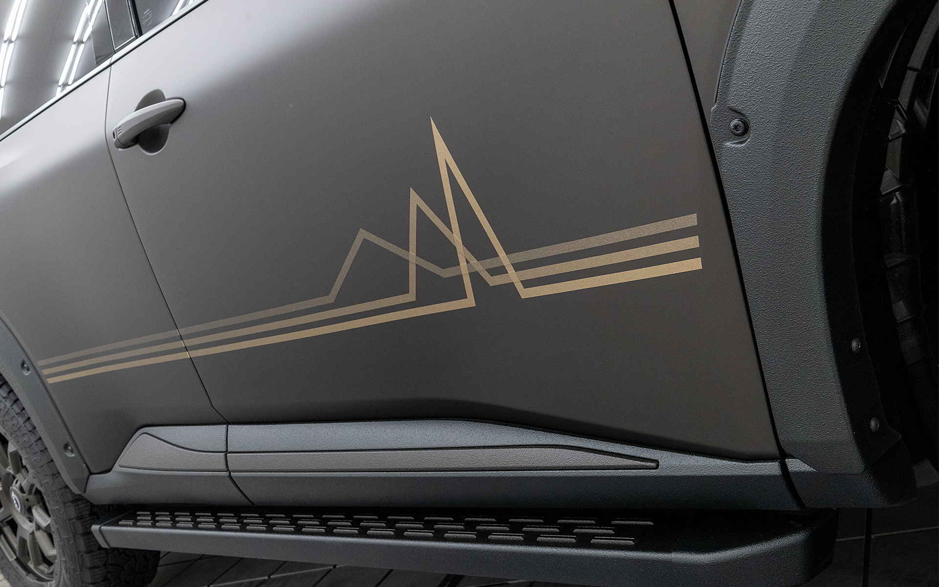 ボディサイドに入るグラフィックは新旧エクストレイルともに共通デザインで、三角の部分は連なる山や電気や音楽の波形を表す。さらにラインの平行部分はテラスのパラメトリックデザインとも調和するよう考えられている