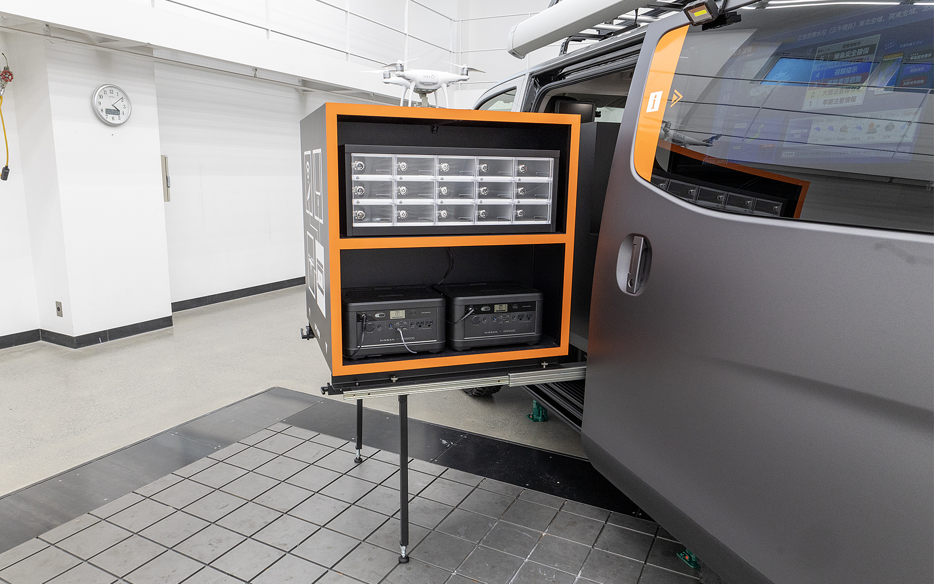 特徴的な装備は車内からスライドして展開することができる棚。上段はスマホが充電できる装備。かぎ付きのボックス内に入れて充電するという作りで、かぎ付きというのがリアル。下段には電源となるポータブルバッテリーfrom LEAFが収納される