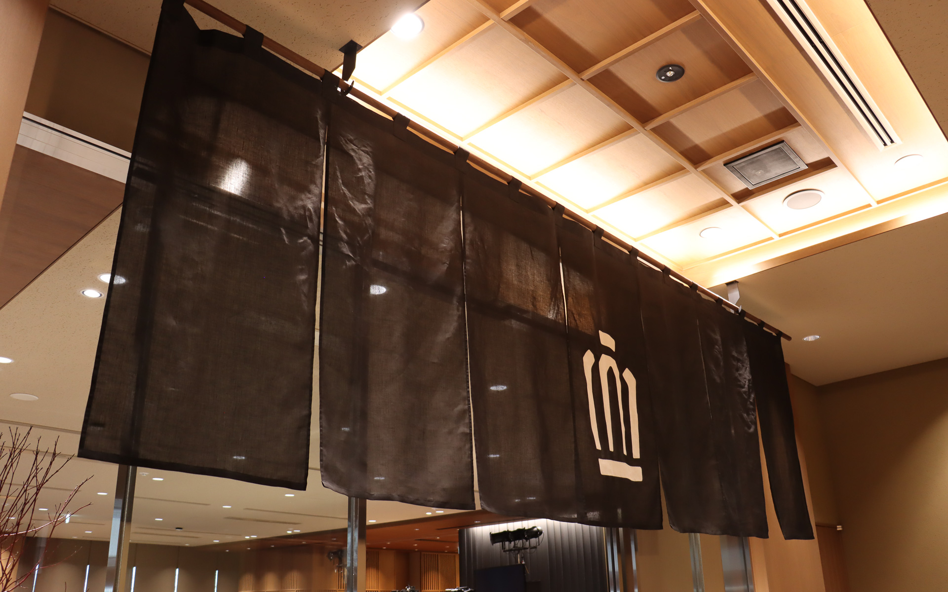 4階にあるTHE CROWN 東京虎ノ門では、エレベーターを出てすぐの場所に王冠マークの入ったのれんがお出迎え。ほかにも店内の至るところに木材や漆喰風の壁などが設定され、和のテイストをアピール